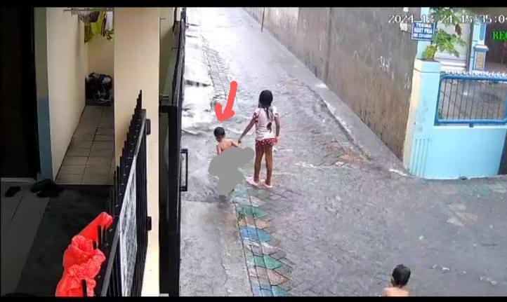 SEBELUM TERSERET ARUS: Rekaman CCTV saat korban (panah merah) tercebur selokan kemudian hilang terbawa arus