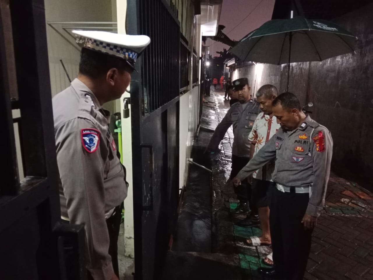 BERARUS DERAS: Petugas menunjukkan lokasi awal tempat korban hanyut di selokan Babatan Wiyung Surabaya.
