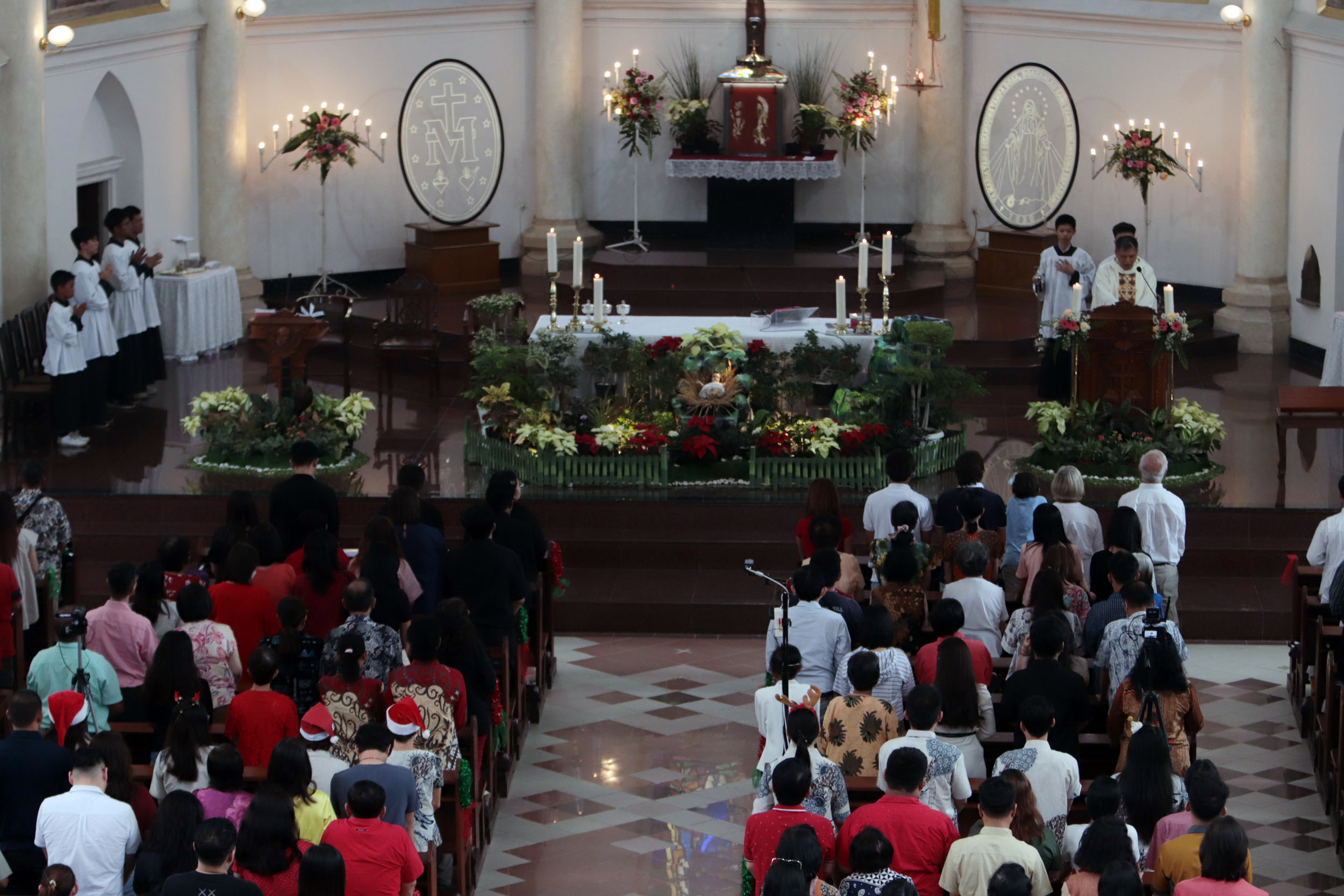 PENUH DAMAI: Umat Kristiani mengikuti Misa Natal di Gereja Katolik Kelahiran Santa Perawan Maria, Kepanjen, Surabaya, Rabu (25/12).