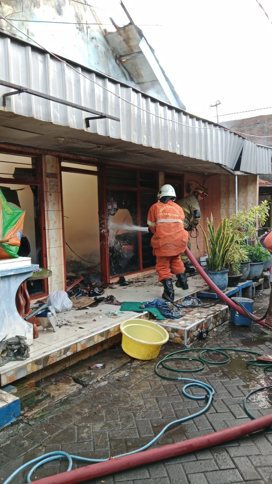 Petugas DPKP Surabaya memadamkan rumah di Jalan Muteran, Surabaya, yang terbakar. (IST)