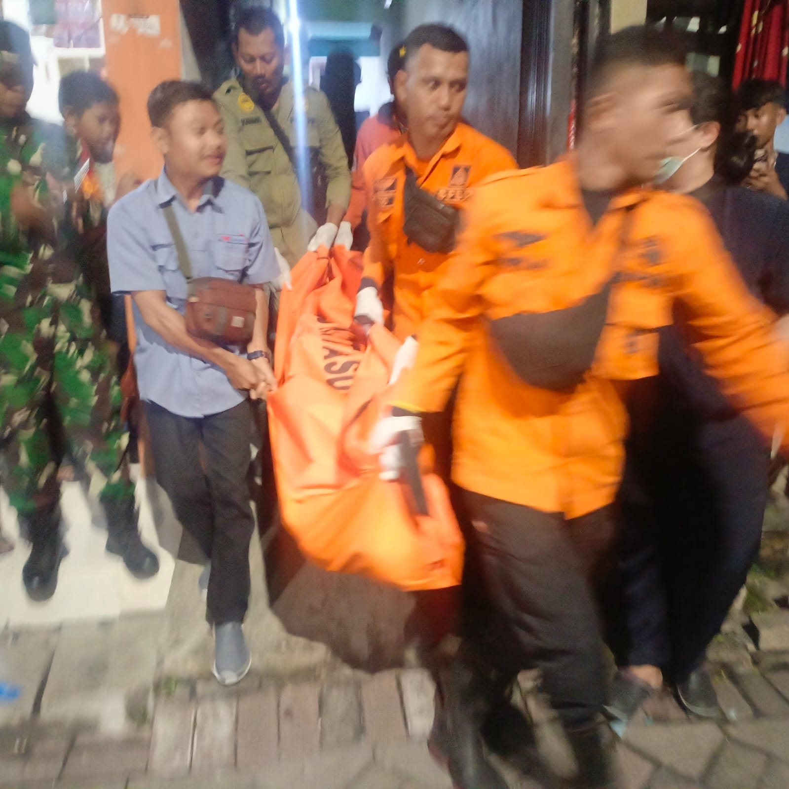 DIEVAKUASI: Petugas BPBD mengangkat mayat korban untuk dibawa ke ambulans menuju RSUD dr Soetomo Surabaya.