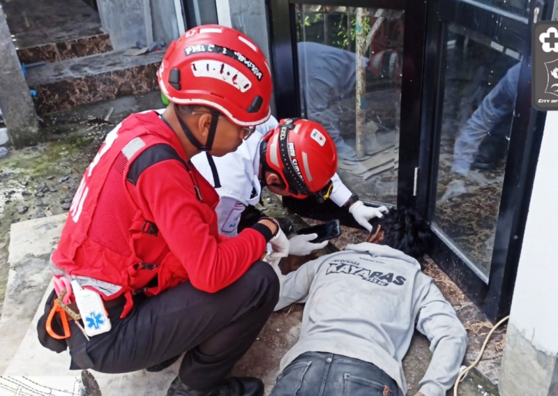 PERIKSA: Petugas memeriksa jenazah korban sebelum dievakuasi ke RSUD dr Soetomo Surabaya.