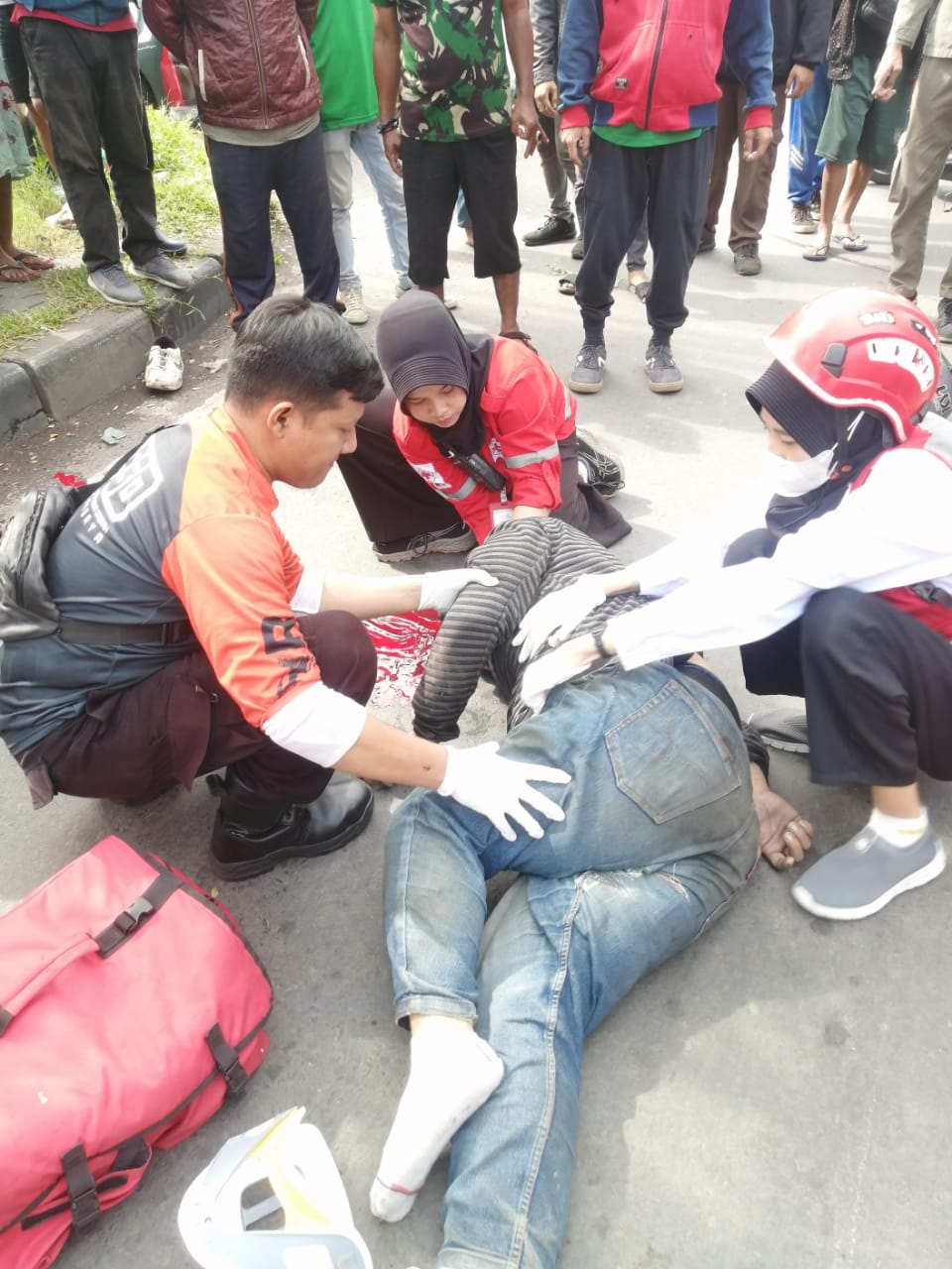 Petugas medis saat memberikan pertolongan awal kepada IH korban laka di Jalan Margomulyo, Tandes Surabaya, Minggu (5/1).