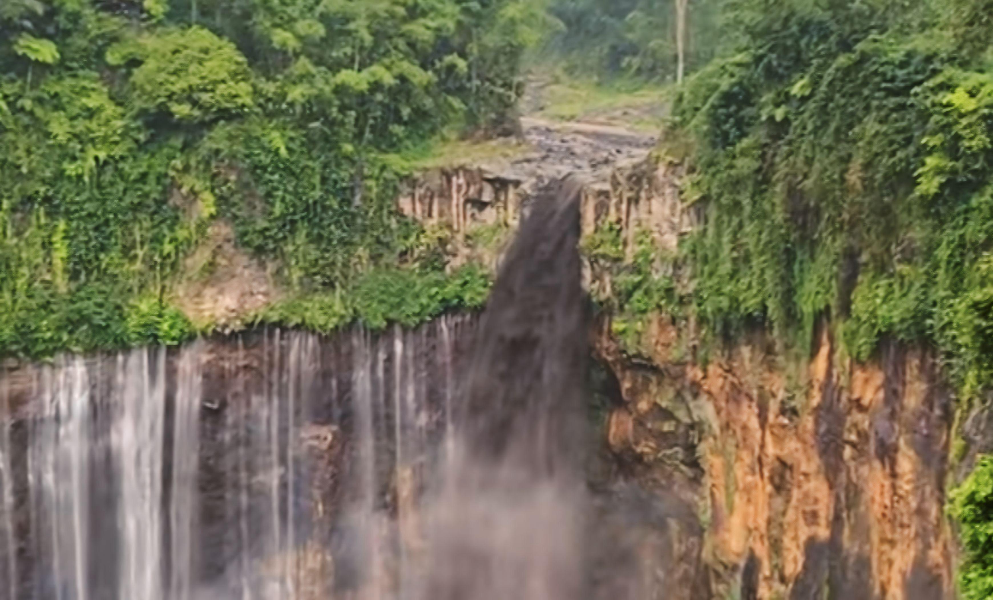 Banjir lahar berwarna hitam kecoklatan mengalir deras di air terjun Tumpak Sewu, Lumajang.