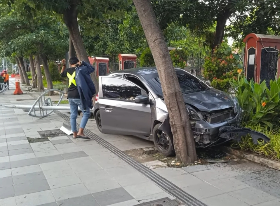Kondisi mobil naik trotoar dan menabrak pohon di FR Jalan Ahmad Yani, Surabaya. (IST)