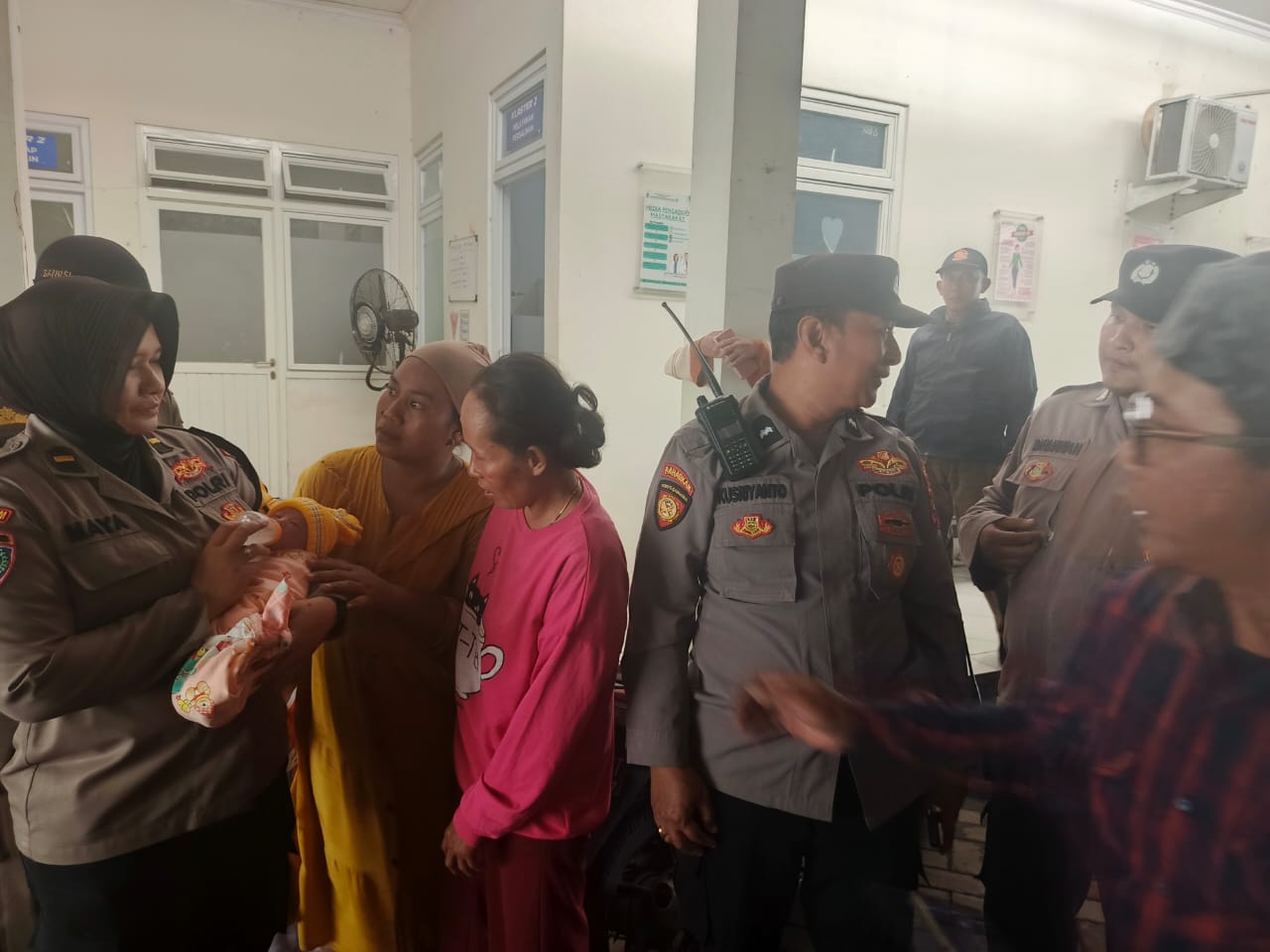 Seorang polwan menggendong bayi yang ditelantarkan di Gunung Anyar Surabaya. (IST)