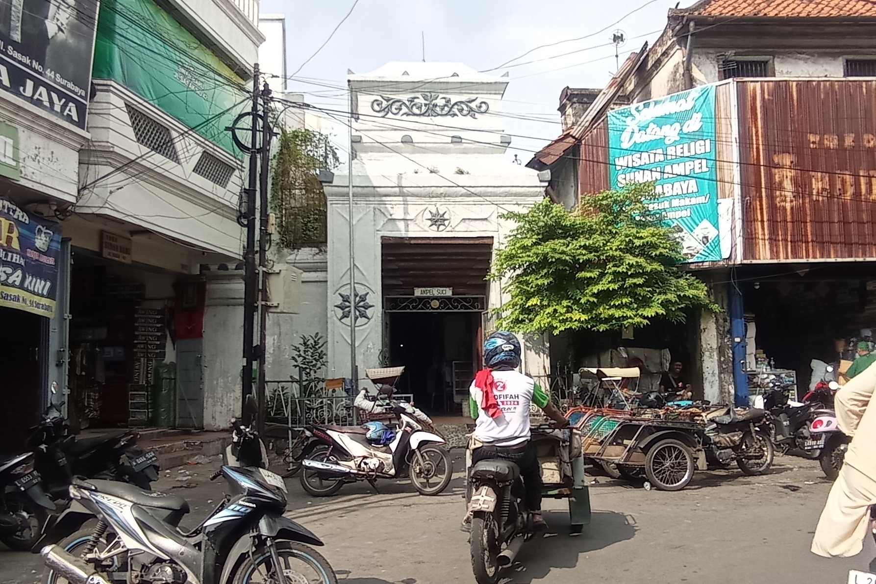 KUNO: Pengendara kendaraan bermotor melintas tak jauh dari gapura kawasan wisata religi Sunan Ampel, Surabaya.&nbsp;