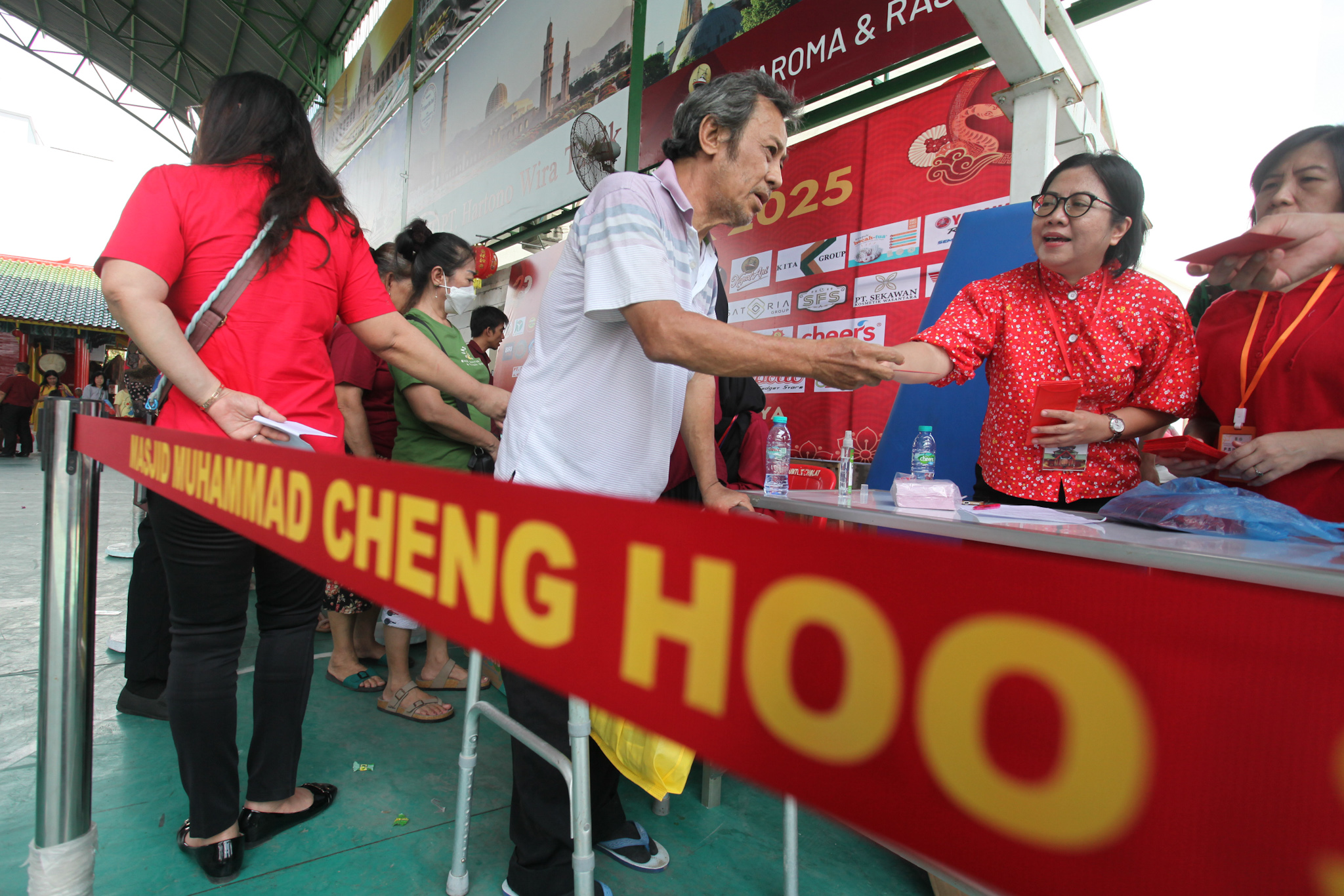 BAHAGIA: Seorang warga mengantre untuk menerima angpao dan bingkisan di halaman Masjid Muhammad Cheng Hoo Surabaya, Sabtu (18/1).