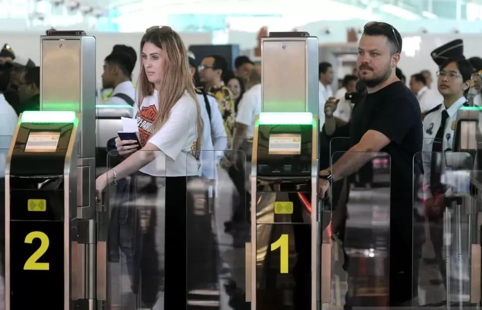 Penumpang memindai paspor dan wajah di autogate imigrasi Terminal 3 Bandara Soekarno-Hatta.