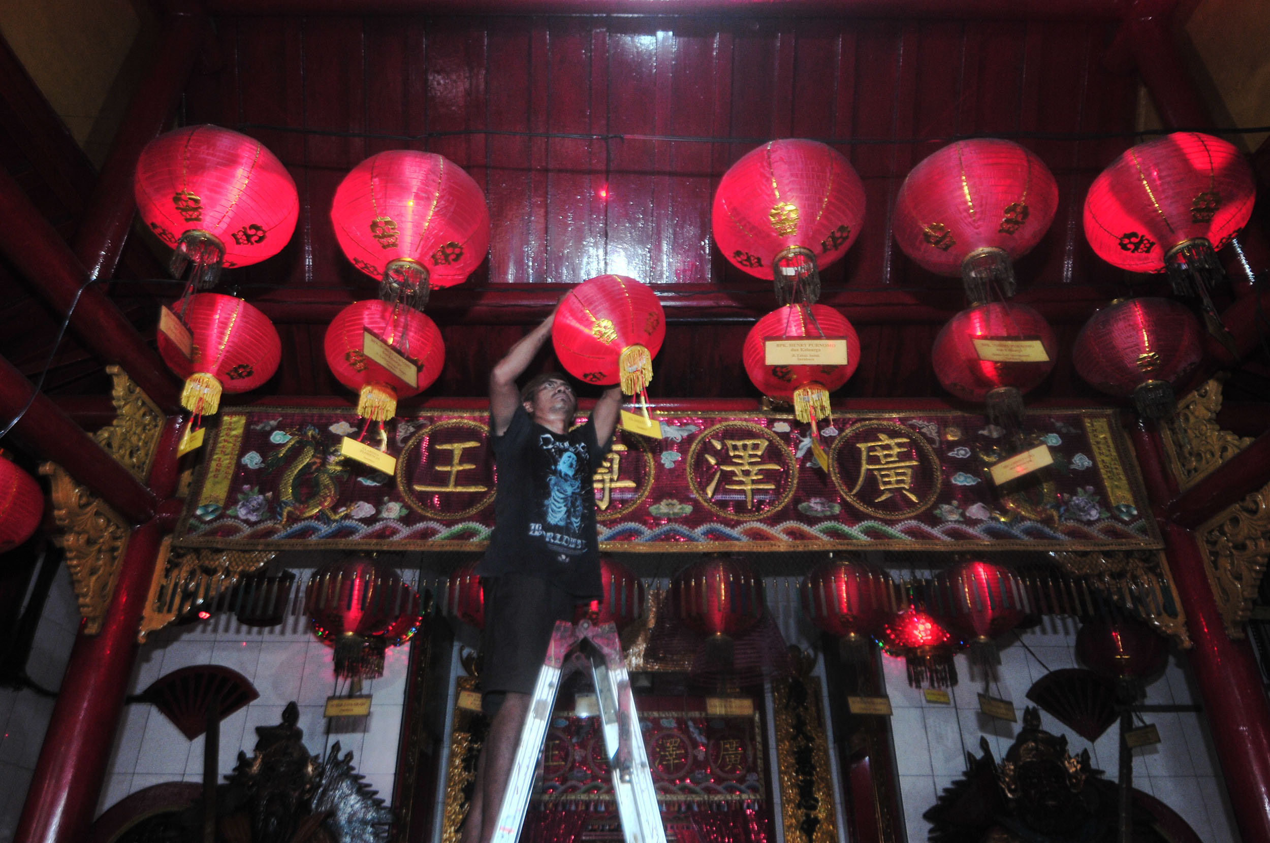 TRADISI TAHUNAN: Sejumlah petugas TITD Hong San Ko Tee bersama umat Tionghoa mengganti lampion-lampion klenteng dengan yang baru untuk menyambut Tahun Baru Imlek.