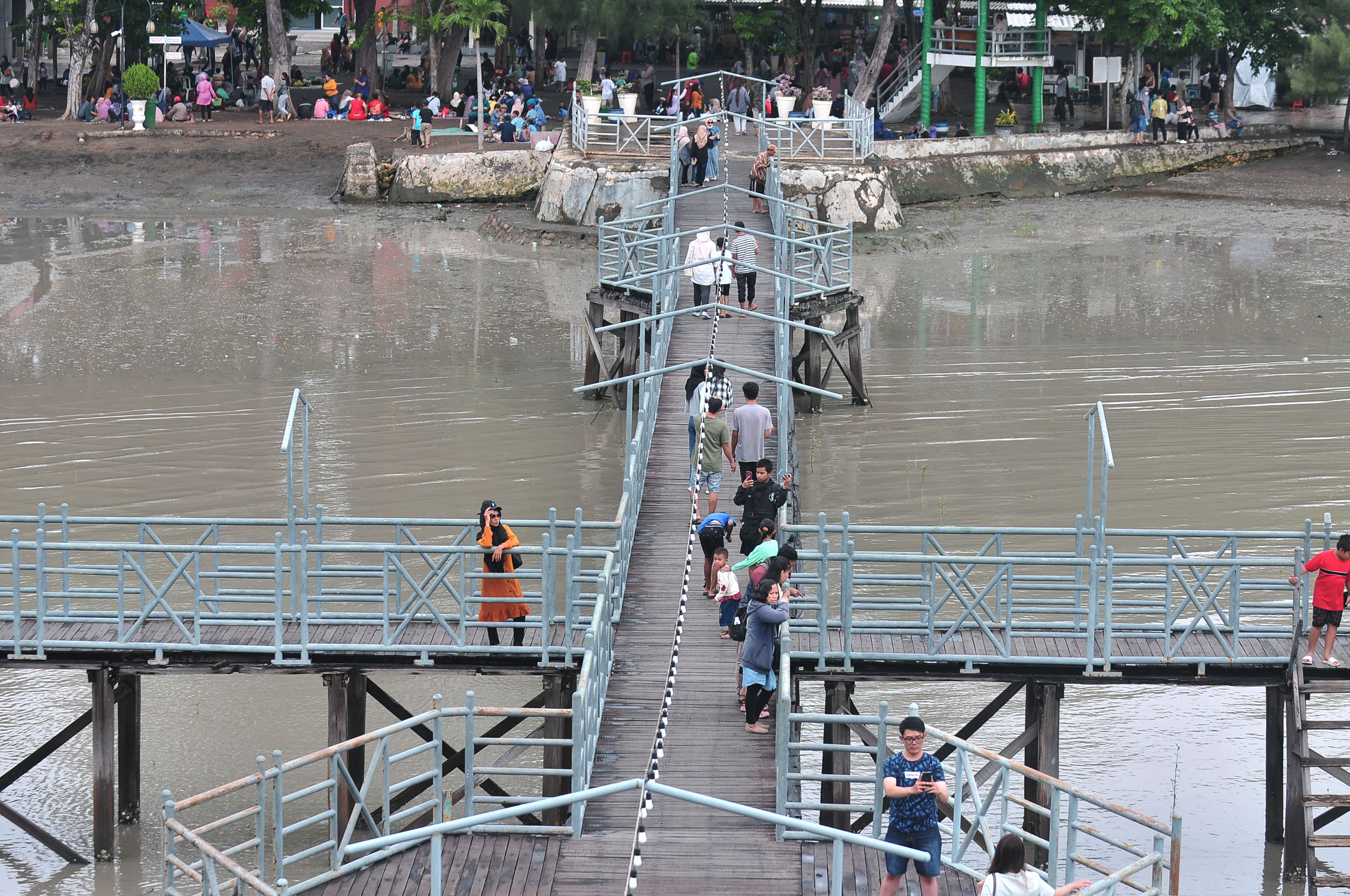 TAK SERAMAI BIASANYA: Pengunjung di THP Kenjeran terlihat asik menikmati wisata, meski kondisi gerimis di kawasan tersebut.