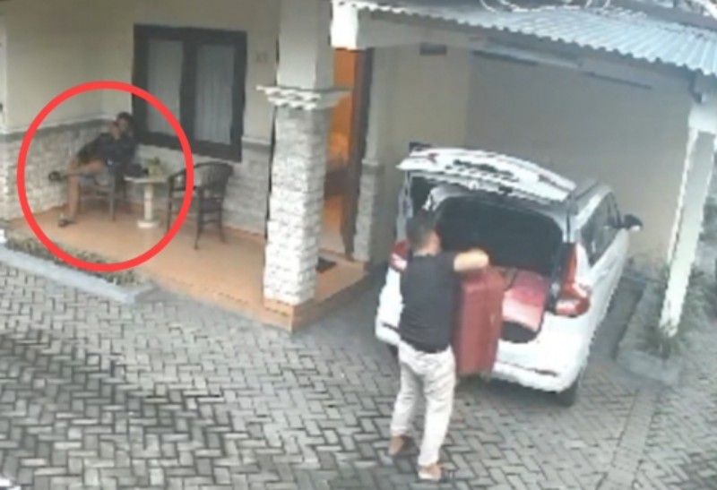 MAM (bulat merah) saat menunggu tersangka RTH menaikkan koper merah berisi potongan jenazah korban UK ke dalam mobil di garasi sebuah penginapan di Kediri.