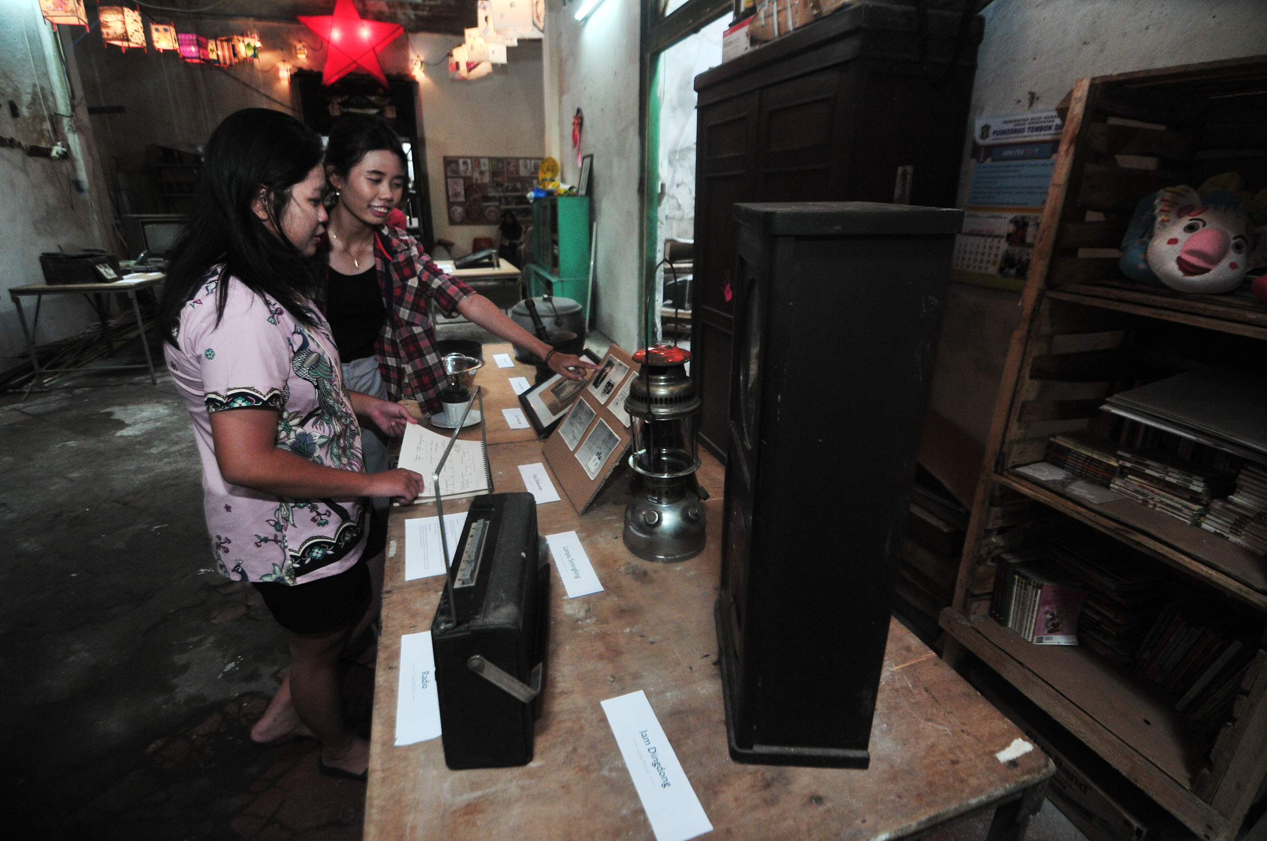 PAMERAN BENDA BIASA: Clara, warga kampung pecinan Tambak Bayan Surabaya, mengamati barang-barang peninggalan leluhurnya yang dipamerkan di Rumah Besar kampung setempat.