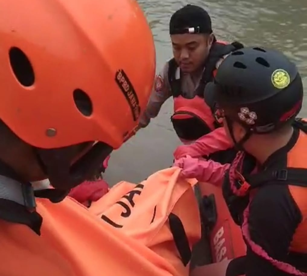 Petugas mengevakuasi jenazah korban setelah ditemukan di sungai Jagir Surabaya.