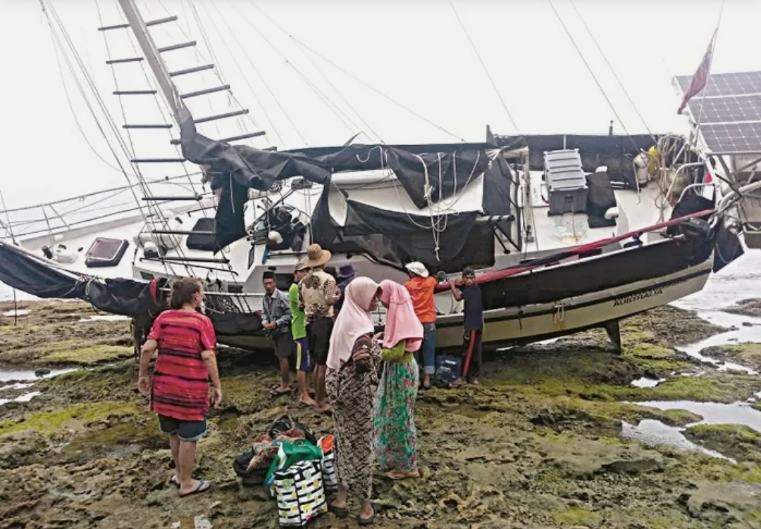Warga melihat kapal warga Australia yang terdampar di perairan Desa Banraas, Pulau Gili Iyang, Kecamatan Dungkek, Sumenep, Kamis (30/1).