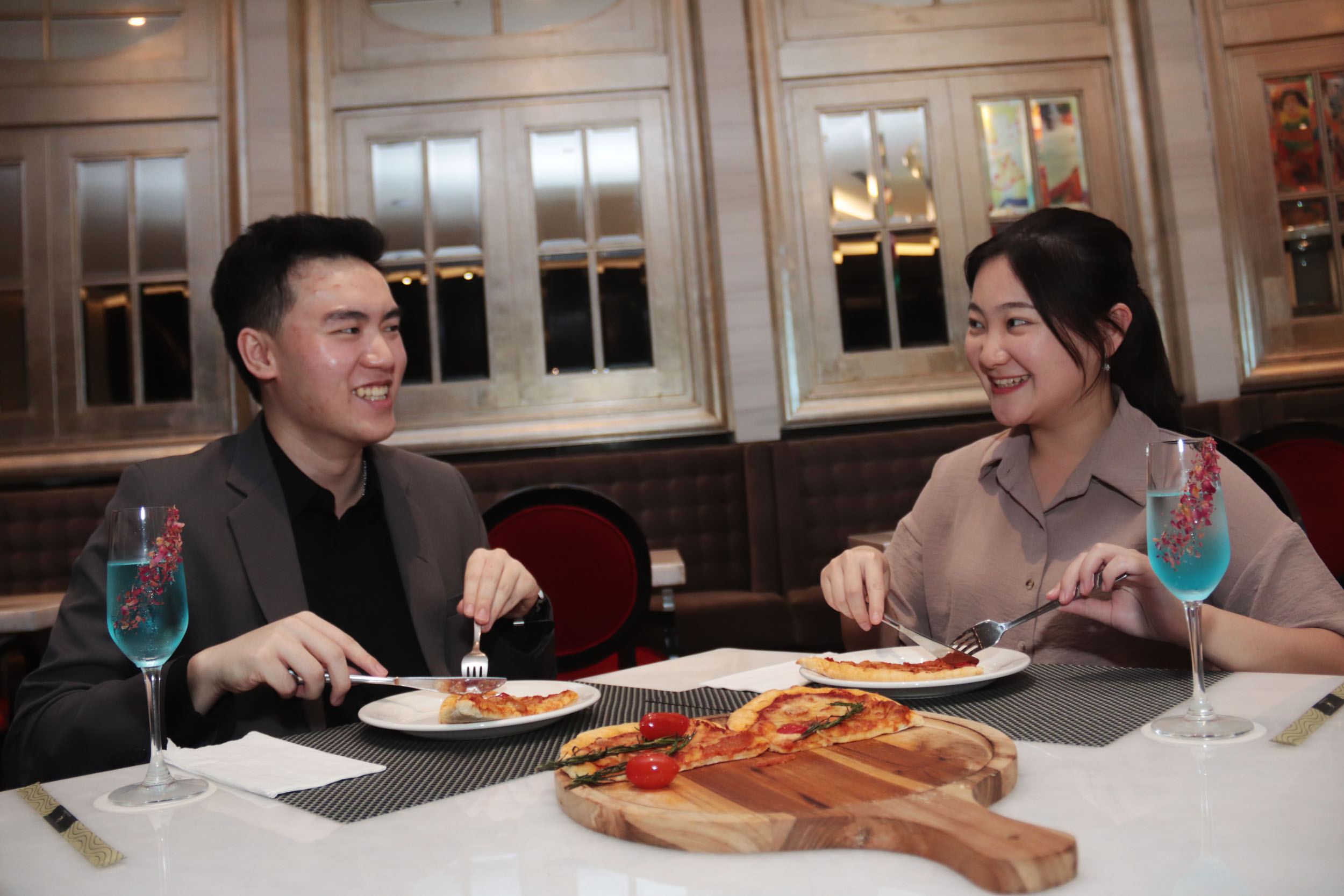 SAMBUT HARI KASIH SAYANG: Erika (kanan) bersama rekannya Nicholas menikmati sajian unik Love Pizza untuk menyambut perayaan hari Valentine di Ciputra Hotel Surabaya.