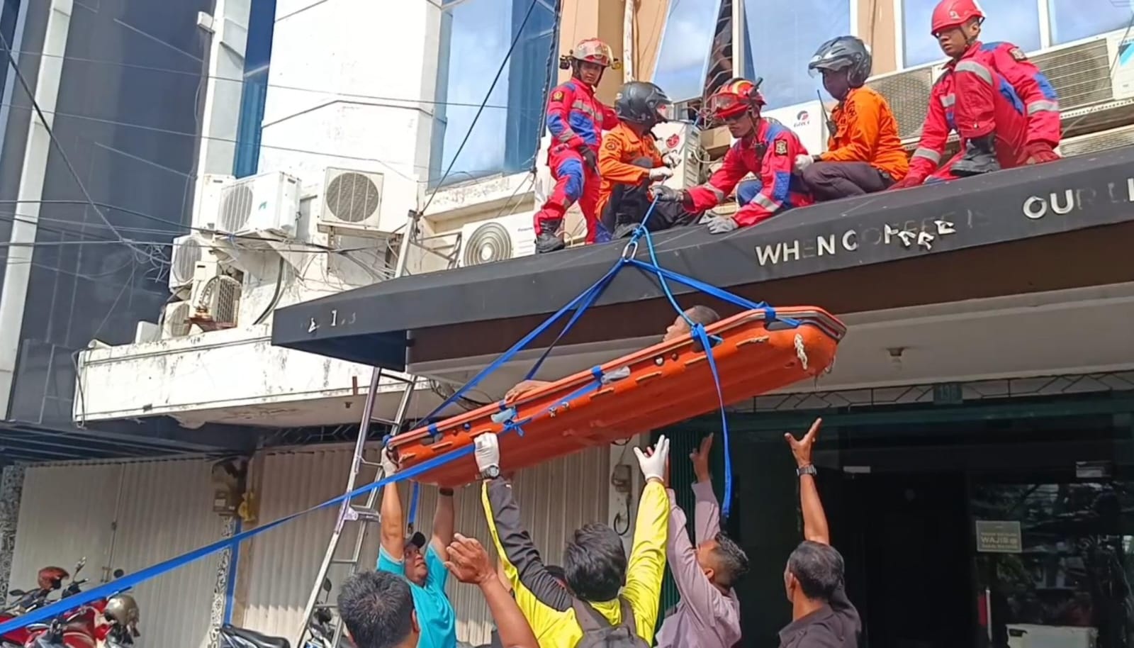 Petugas mengevakuasi Suyadi yang tersengat listrik di Jalan Klampis Jaya Surabaya. (IST)