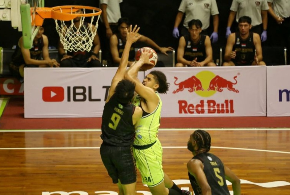 Pebasket Pacific Caesar Surabaya Miguel Angel Miranda (tengah) coba lakukan lay up dan diblok pemain Bima Perkasa Jogja.