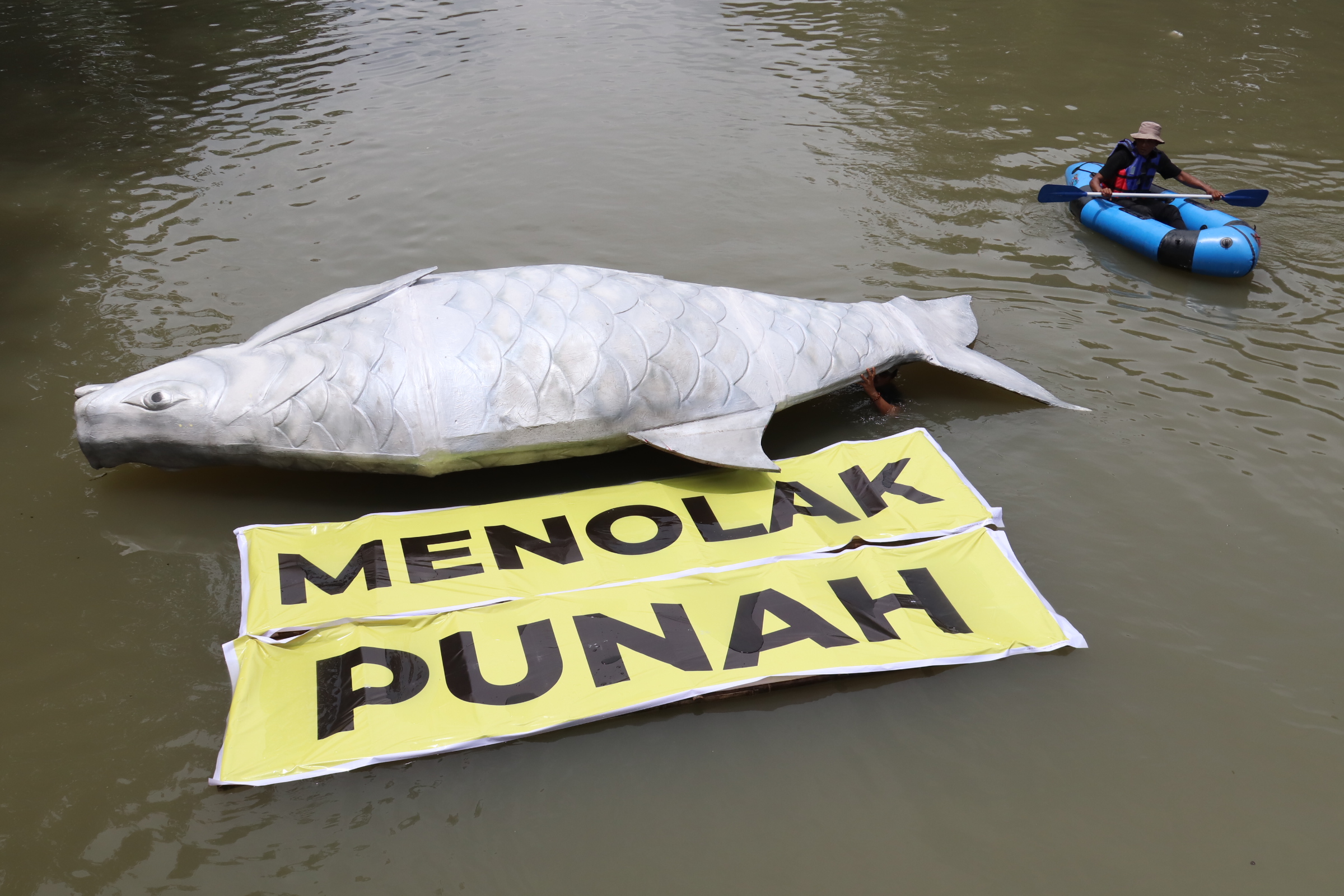 PENCEMARAN LINGKUNGAN: Aktivis lingkungan menggelar aksi teatrikal tolak ikan punah di aliran Kalimas, Ngagel, Surabaya.&nbsp;