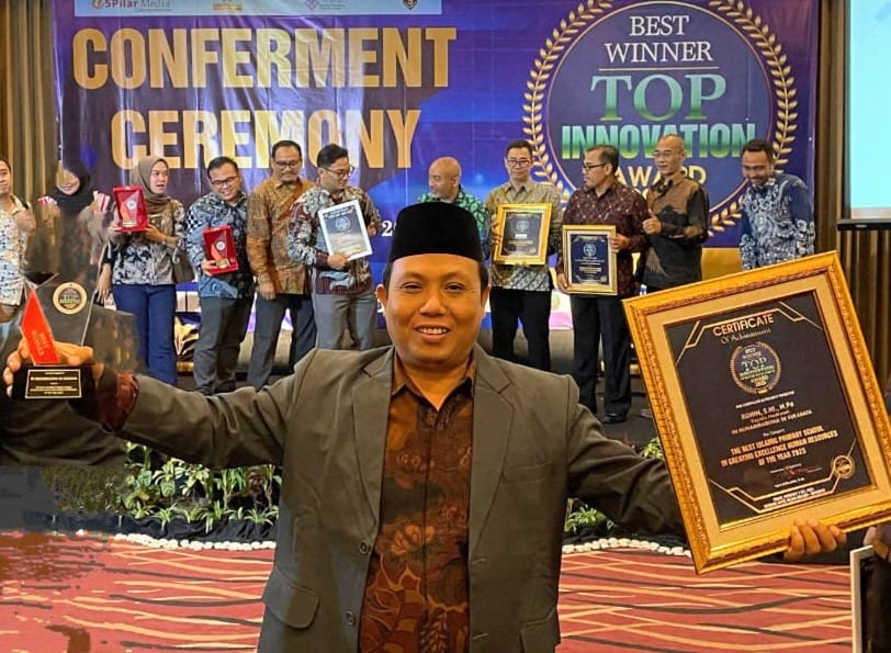 BERPRESTASI: Rohim S.H.I., M.Pd., menunjukan trophy dan sertifikat penghargaan kategori The Best Islamic Primary School in Creating Excellence Human Resource of The Year 2025.