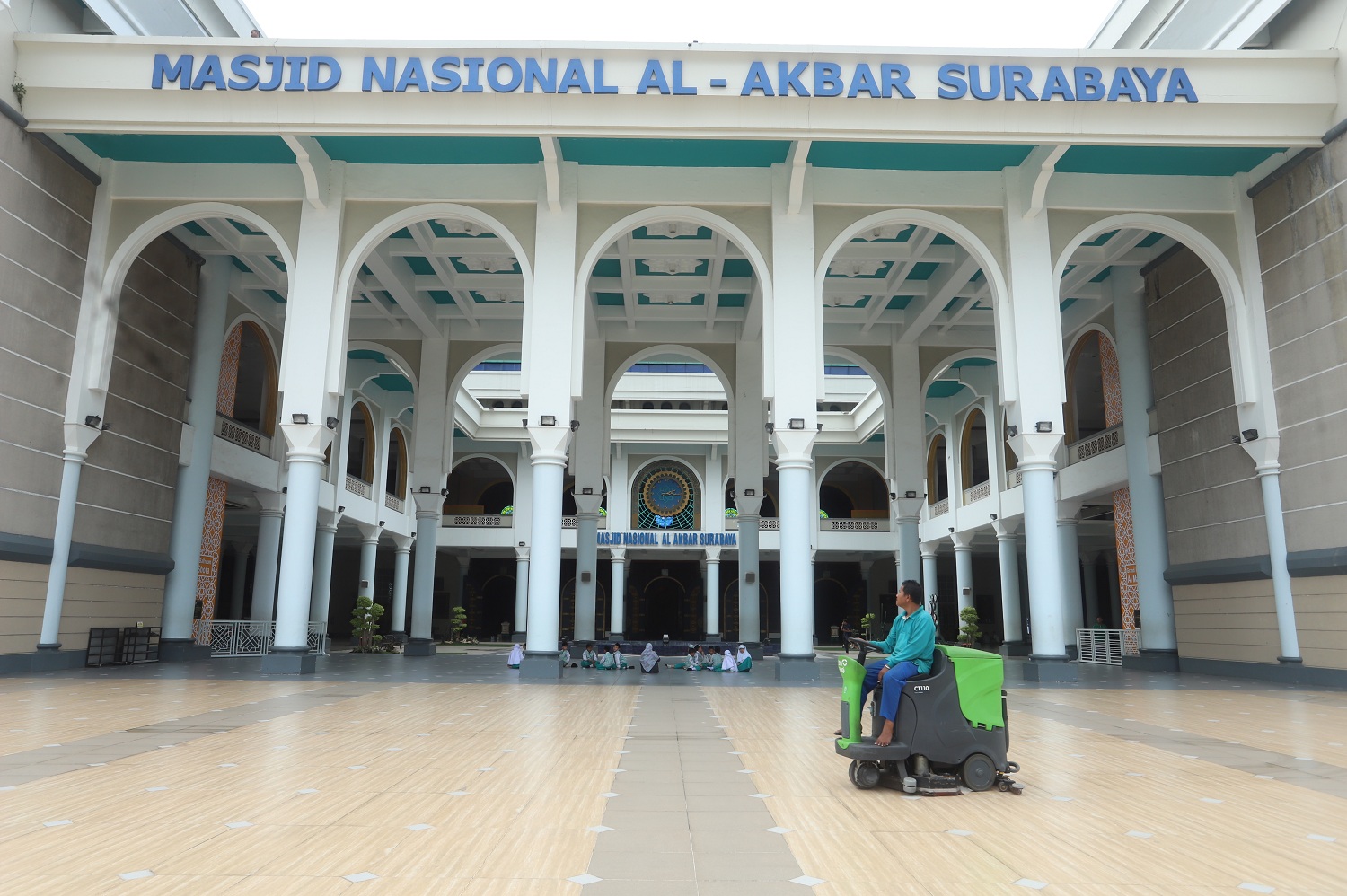 Pekerja membersihkan area masjid Al Akbar di Surabaya.