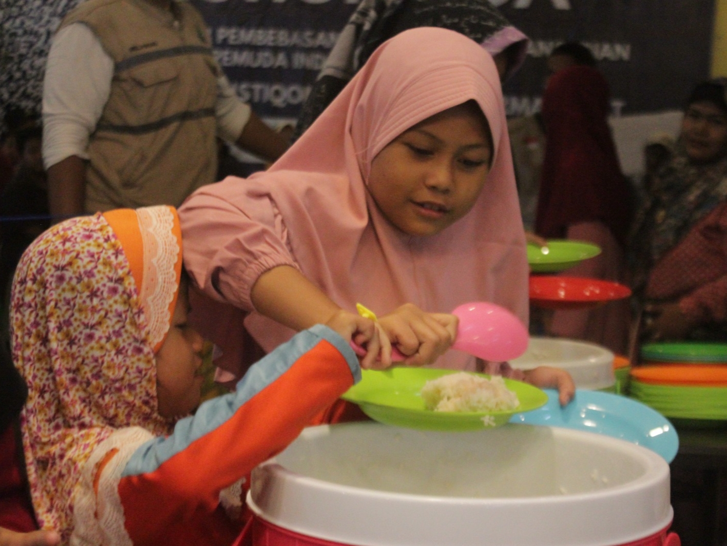 BERBAGI KEBAIKAN: Dua orang anak saat mengambil makanan berbuka puasa di Masjid Pemuda Konsulat, Surabaya, yang disediakan secara gratis.