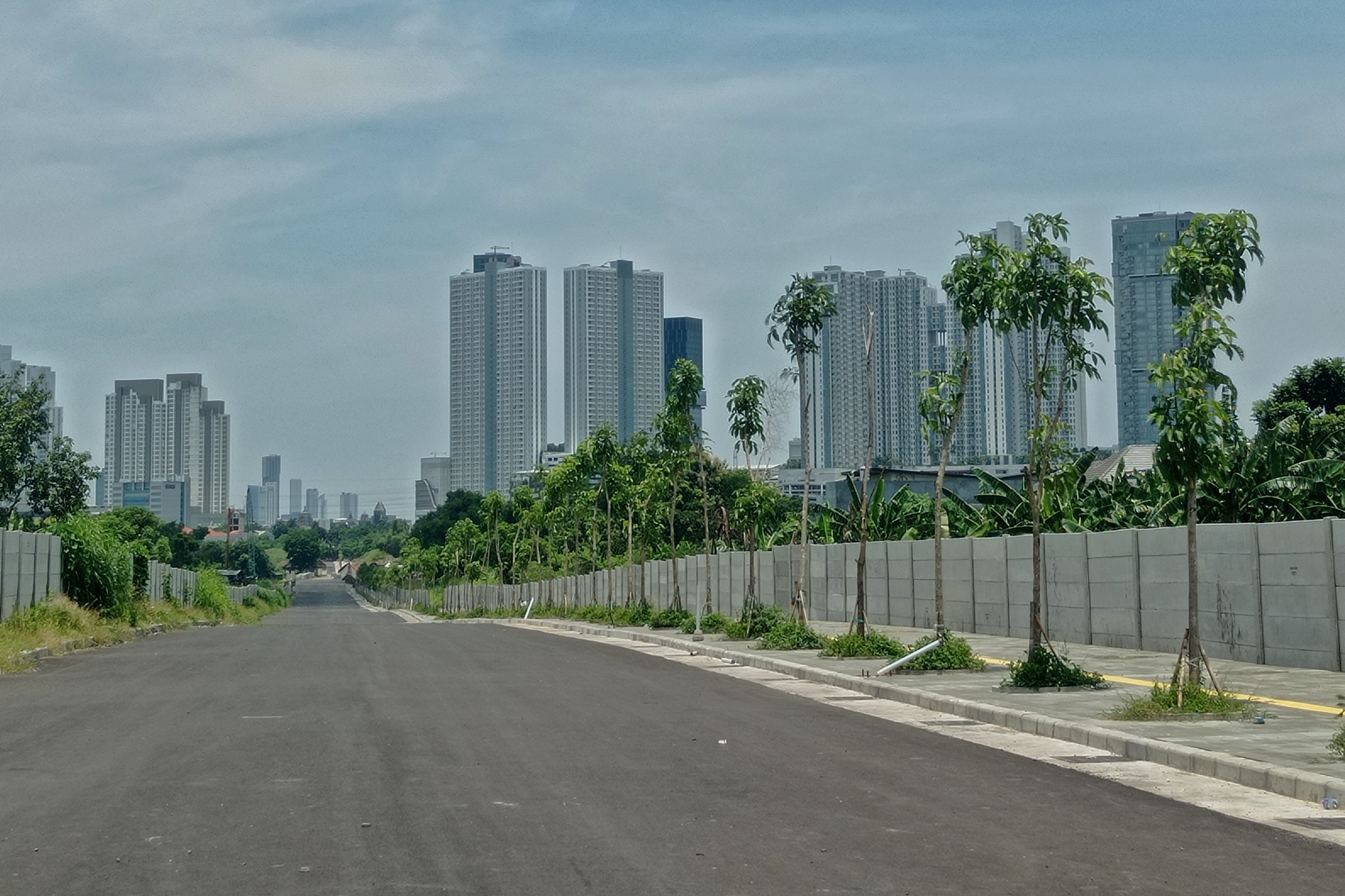 BELUM DIBUKA: Warga melintas tak jauh dari proyek jalan Radial Road di kawasan Lakarsantri, Surabaya.&nbsp;