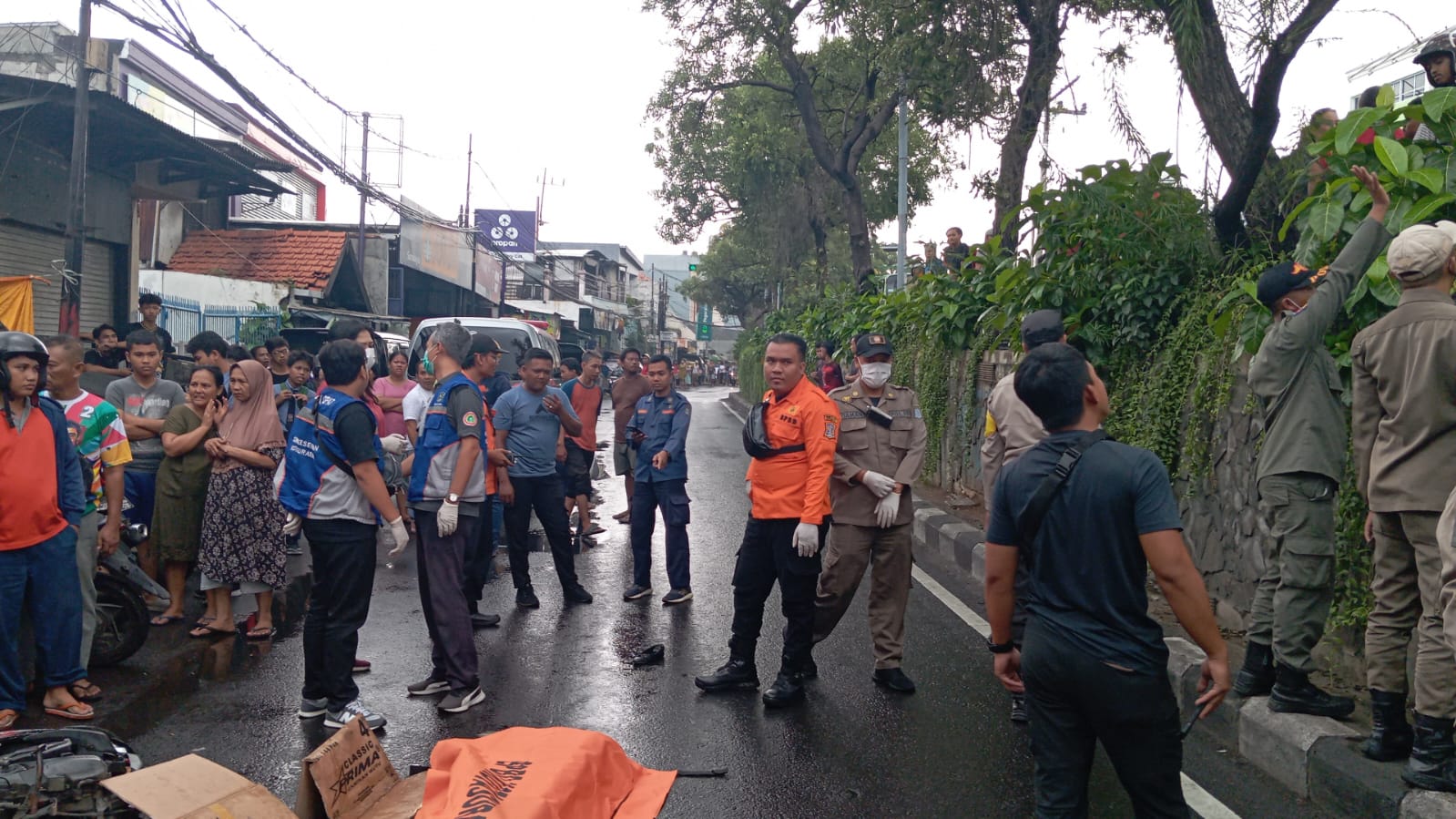 NAHAS : Petugas saat mengevakuasi mayat Andien Agustina Gasmi korban kecelakaan di Jalan Banyuurip, Surabaya. (IST)