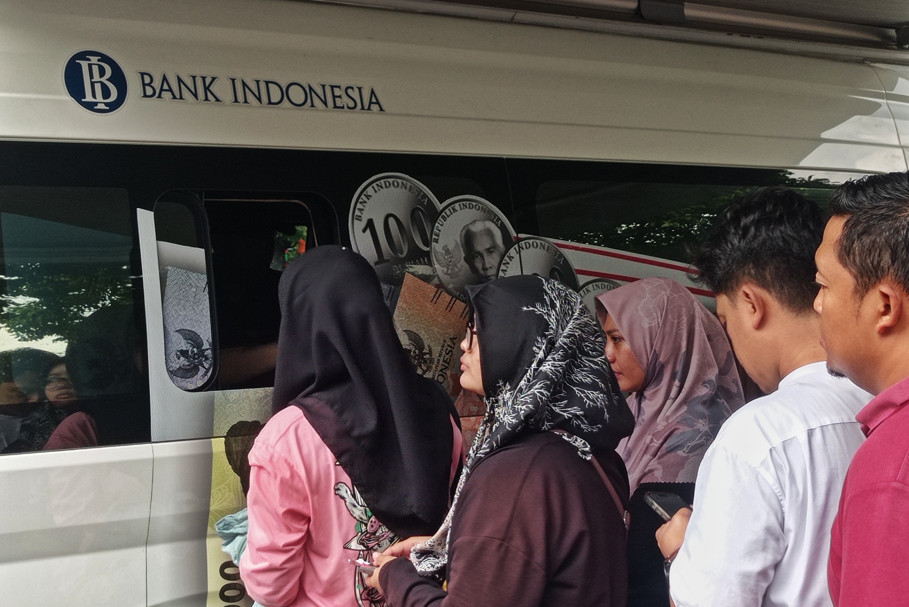 Warga antre menukarkan uang baru di mobil kas keliling Bank Indonesia.