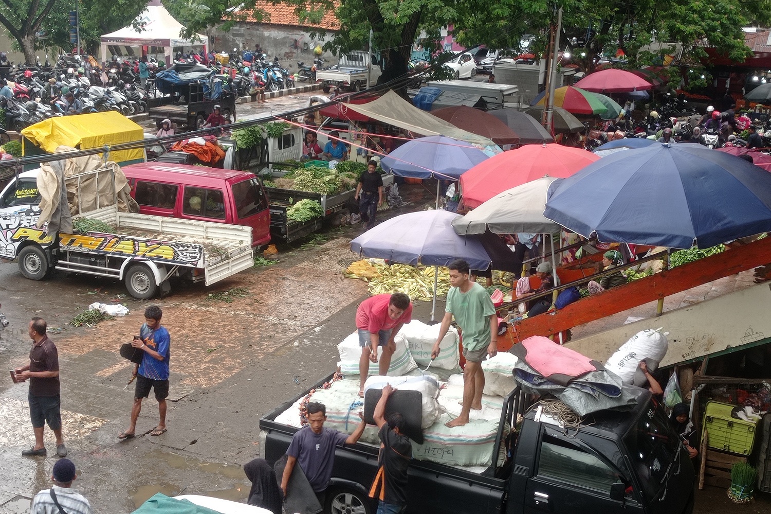 Aktivitas bongkar muat barang di area Pasar Keputran, Surabaya.