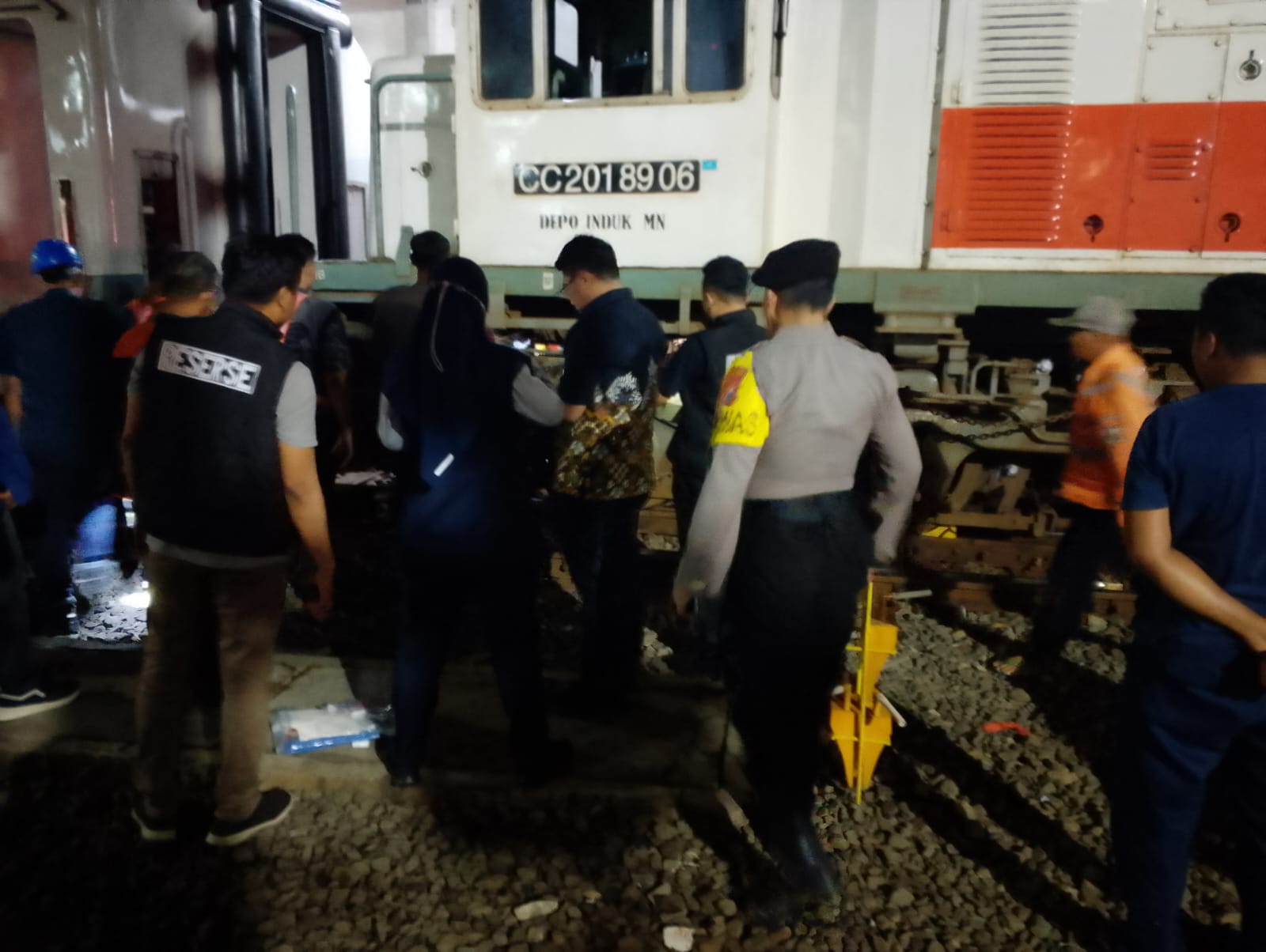 EVAKUASI : Tim gabungan dari Polsek Pabean Cantikan dan BPBD Kota Surabaya evakuasi korban di bawah rel kereta api.
