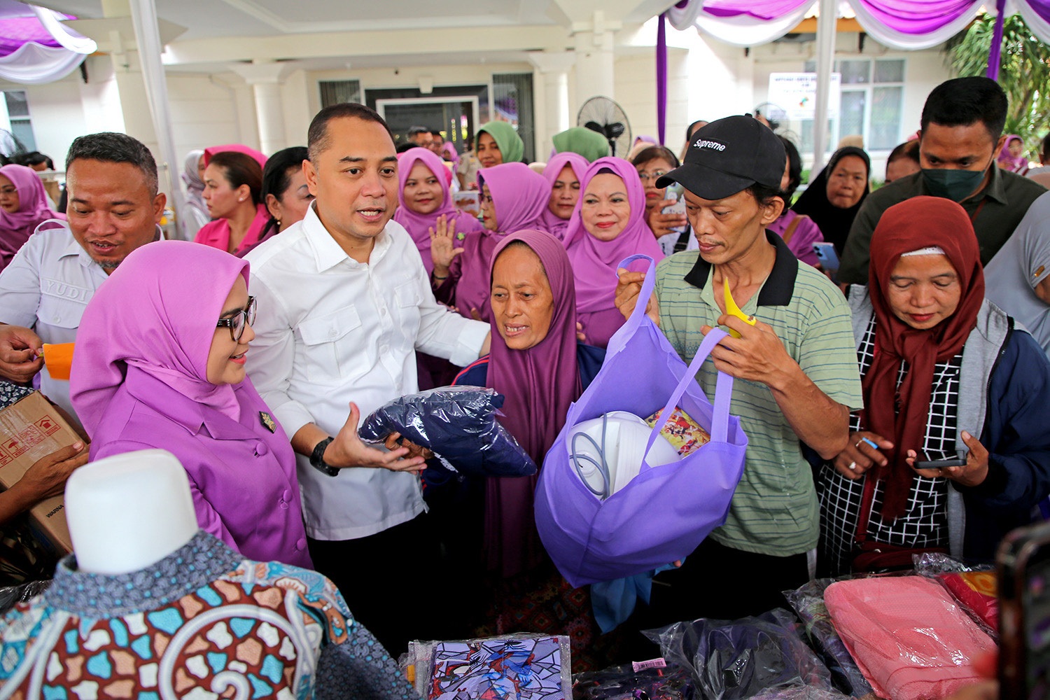 Wali Kota Surabaya Eri Cahyadi bersama Ketua Umum GOW Surabaya Rini Indriyani memberikan barang kebutuhan rumah tangga kepada gakin dalam Garage Day 2025.