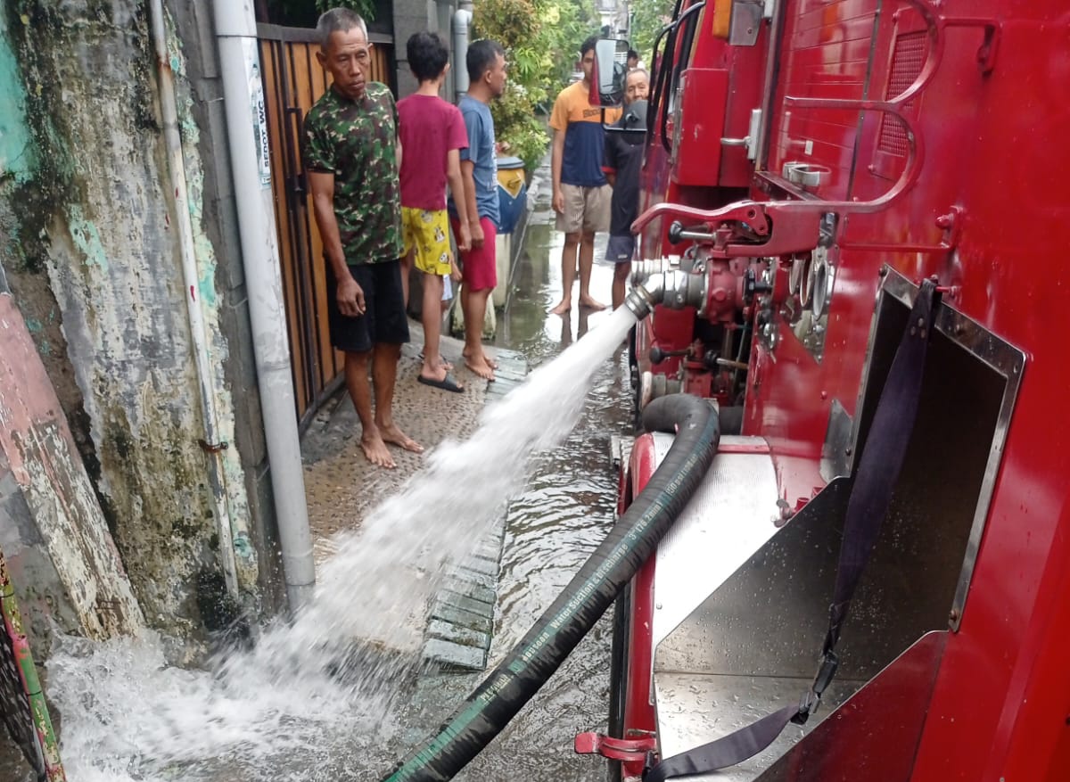 Mobil pemadam kebakaran melakukan penyedotan air yang menggenang pemukiman di salah satu kawasan Surabaya.