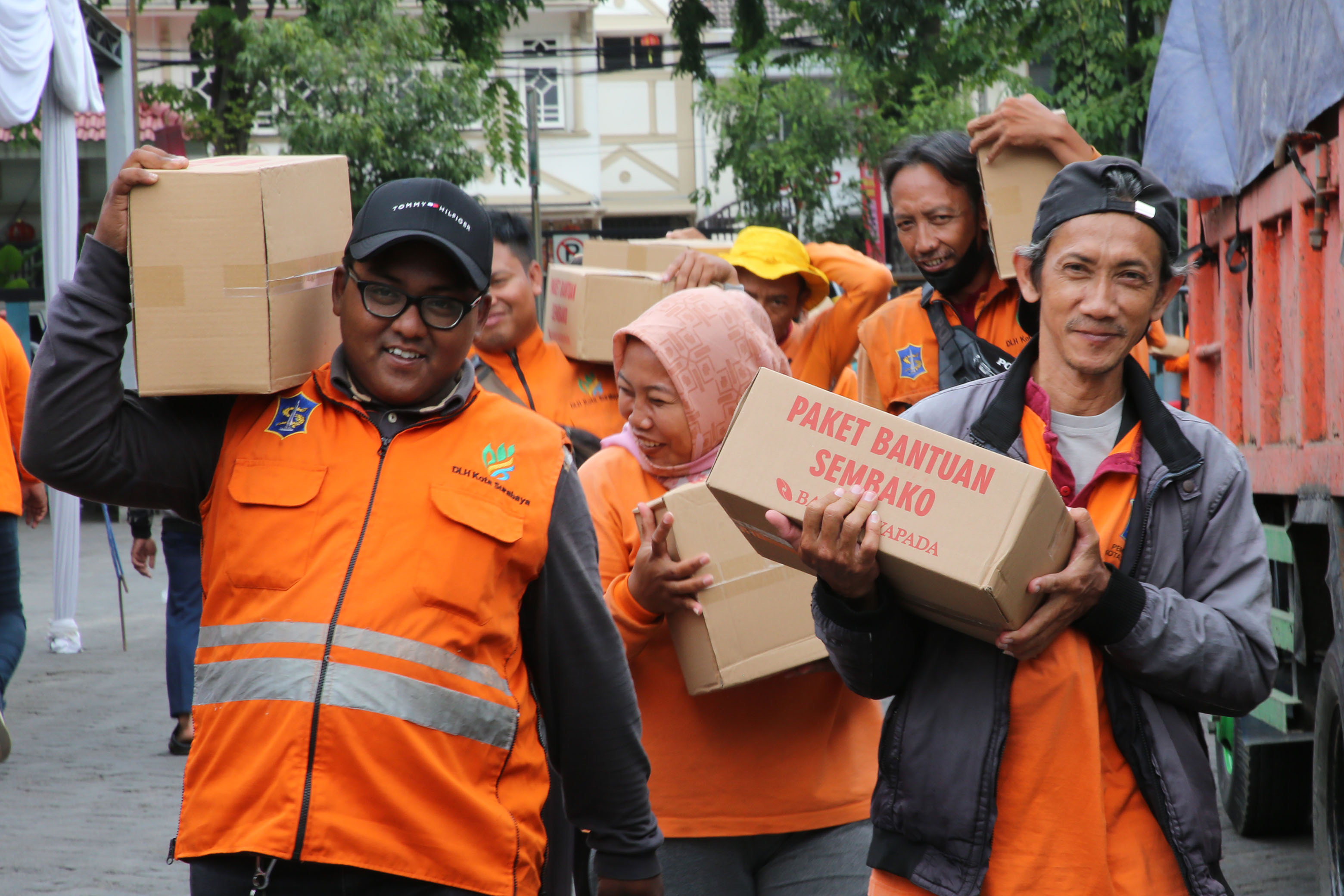 SUMRINGAH: Sejumlah anggota satgas kebersihan DLH Surabaya saat menerima bingkisan sembako.