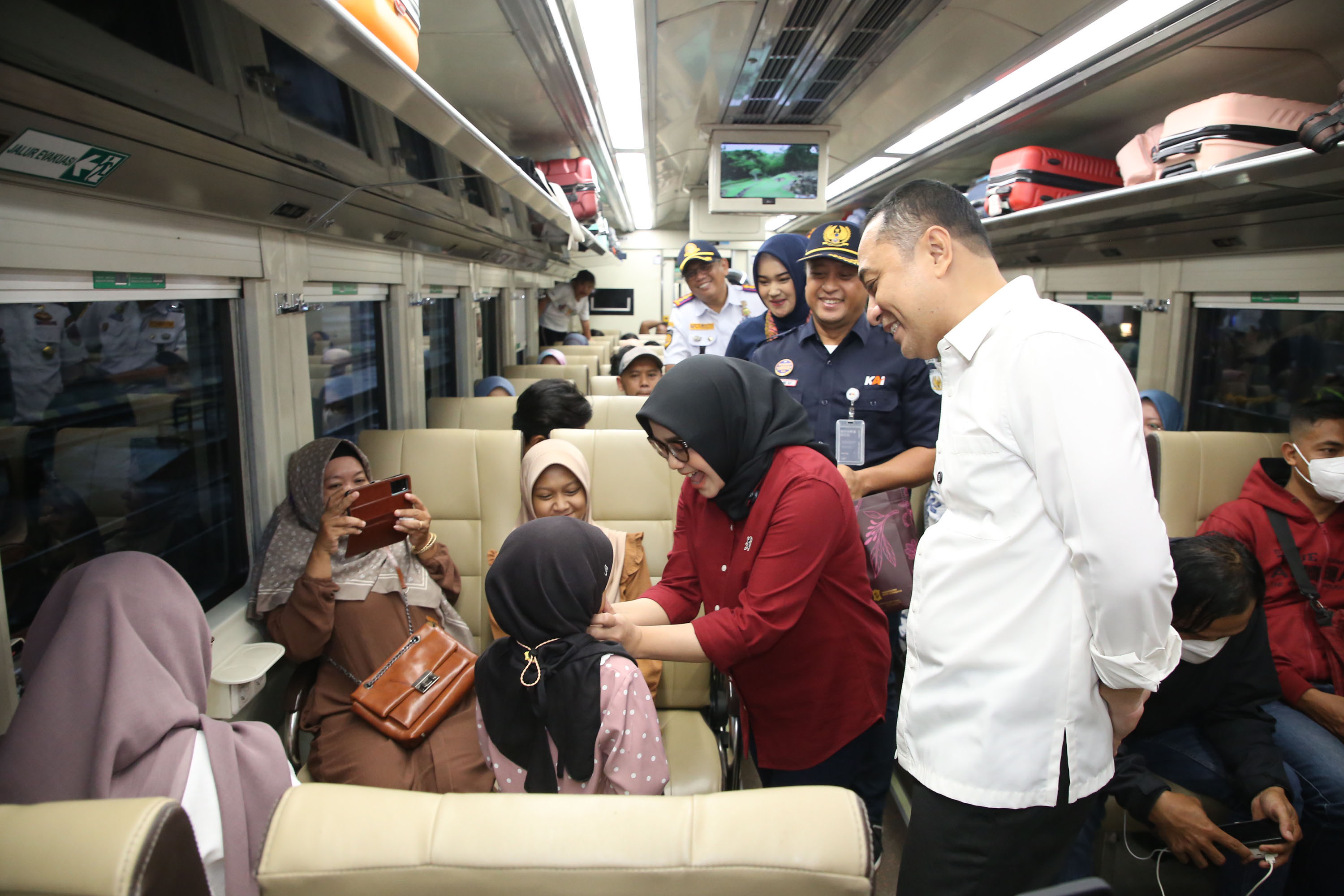 BAHAGIA: Wali Kota Surabaya Eri Cahyadi bersama Ketua TP PKK Kota Surabaya Rini Eri Cahyadi menyapa dan membagikan bingkisan kepada pemudik dengan moda transportasi kereta api di Stasiun Gubeng.