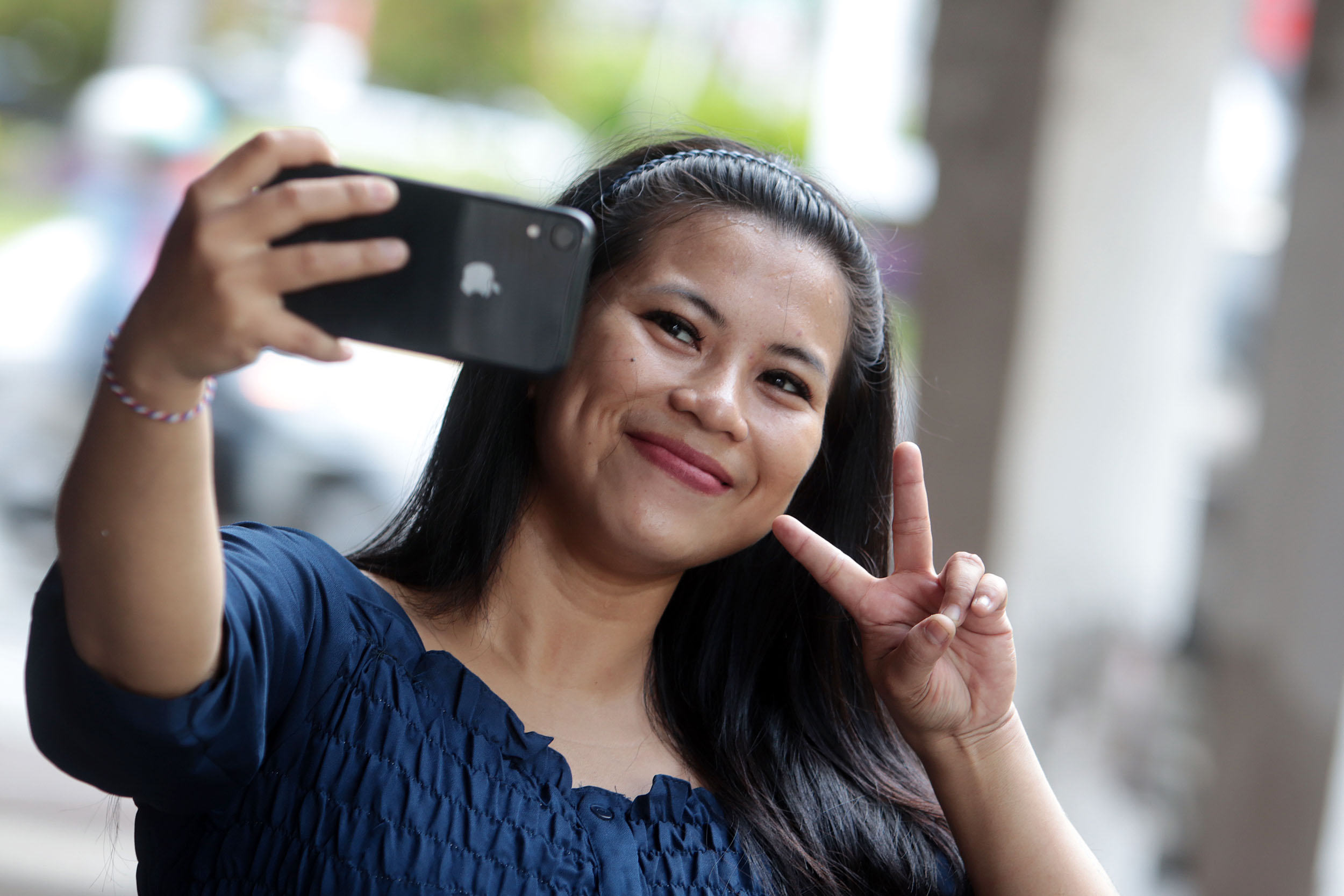 Ilustrasi seorang yang menggunakan gawainya dengan merk Iphone.