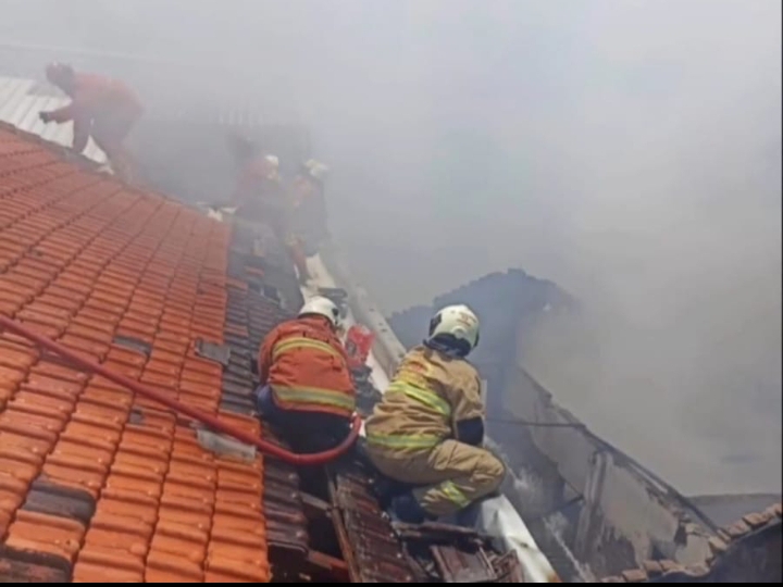 Petugas berusaha memadamkan kebakaran di salah satu rumah di Surabaya. (IST)