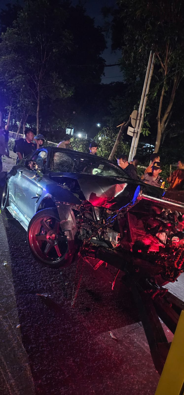 NAHAS : Petugas mengevakuasi mayat Aditya Febriansyah Nur Fauzi korban laka ditabrak mobil BMW di TMP Jalan Mayjen Sungkono, Surabaya, Minggu (13/4). Kondisi mobil ringsek. (IST/RADAR SURABAYA)
