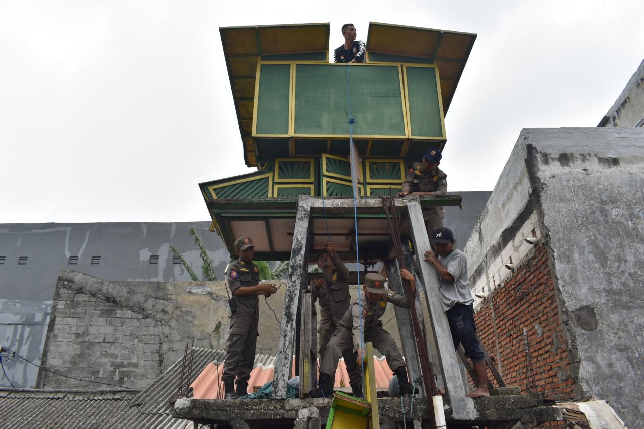 Petugas membongkar bekupon di kawasan Petemon Surabaya. (SURYANTO/RADAR SURABAYA)
