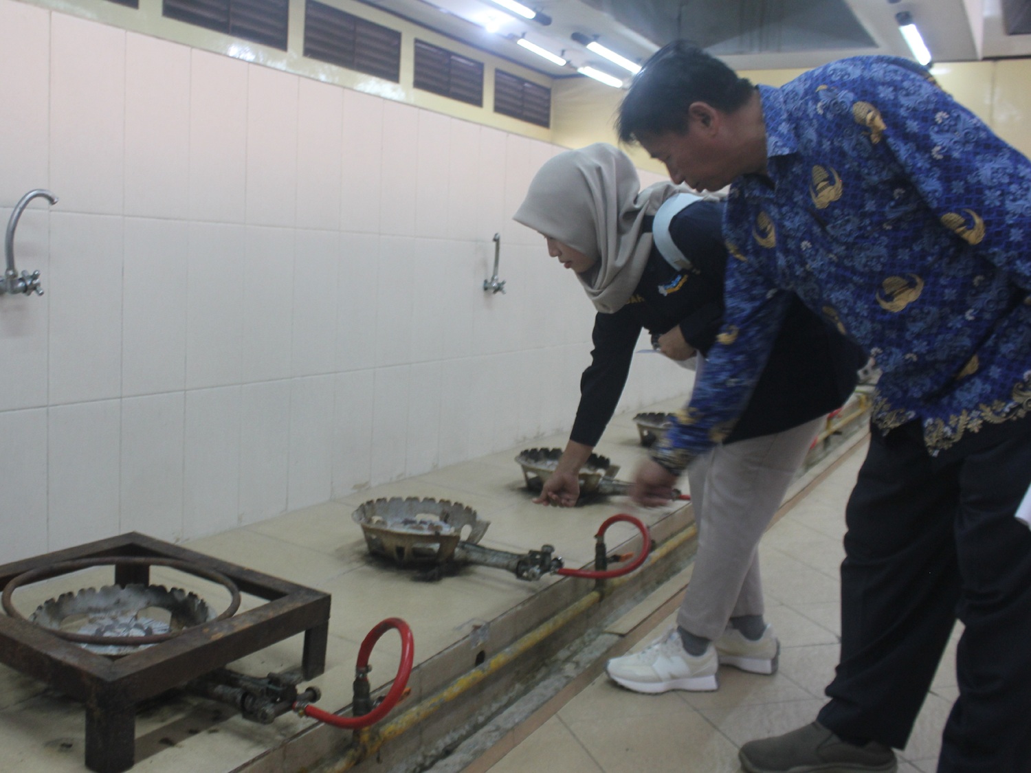 AREA DAPUR: Petugas gabungan dari BBKK Surabaya, Kanwil Kemenag Jatim hingga Dinkes Surabaya melakukan pemeriksaan kesehatan dan sanitasi lingkungan di Asrama Haji Sukolilo Surabaya.