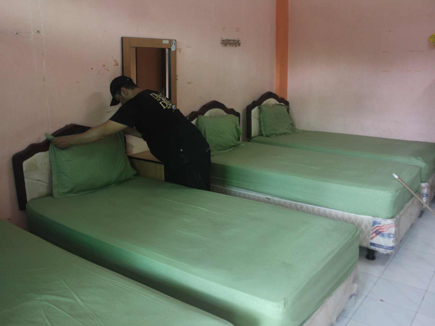 PERSIAPAN: Petugas UPT Asrama Haji Sukolilo Surabaya saat membersihkan dan mempersiapkan kamar khusus lansia yang ada di lantai bawah.
