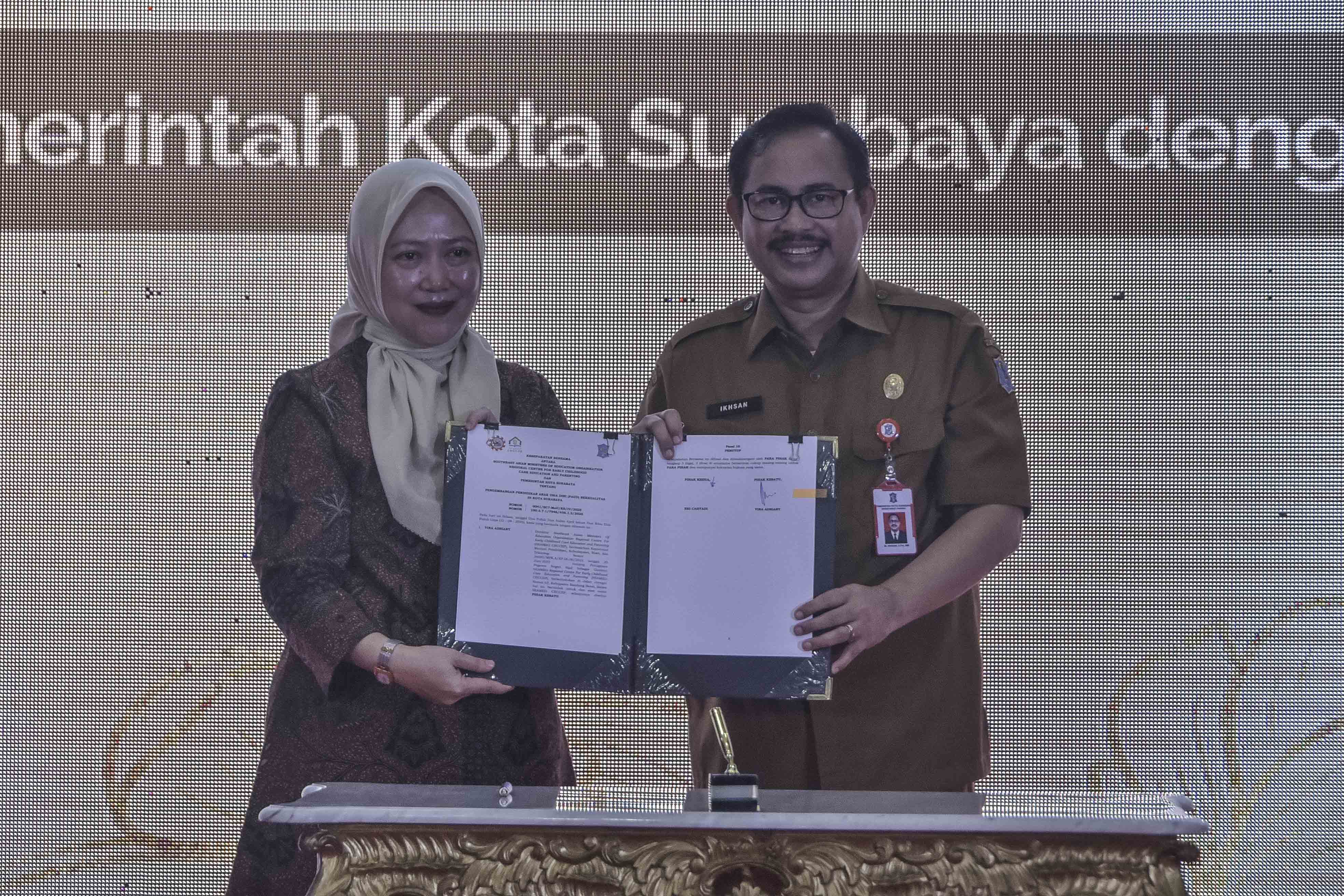 Sekda Kota Surabaya Ikhsan dan Direktur SEAMEO CECCEP Prof. Vina Adriany usai menandatangani nota kesepahaman implementasi Modul Gembira di Graha Sawunggaling, Selasa (22/4).