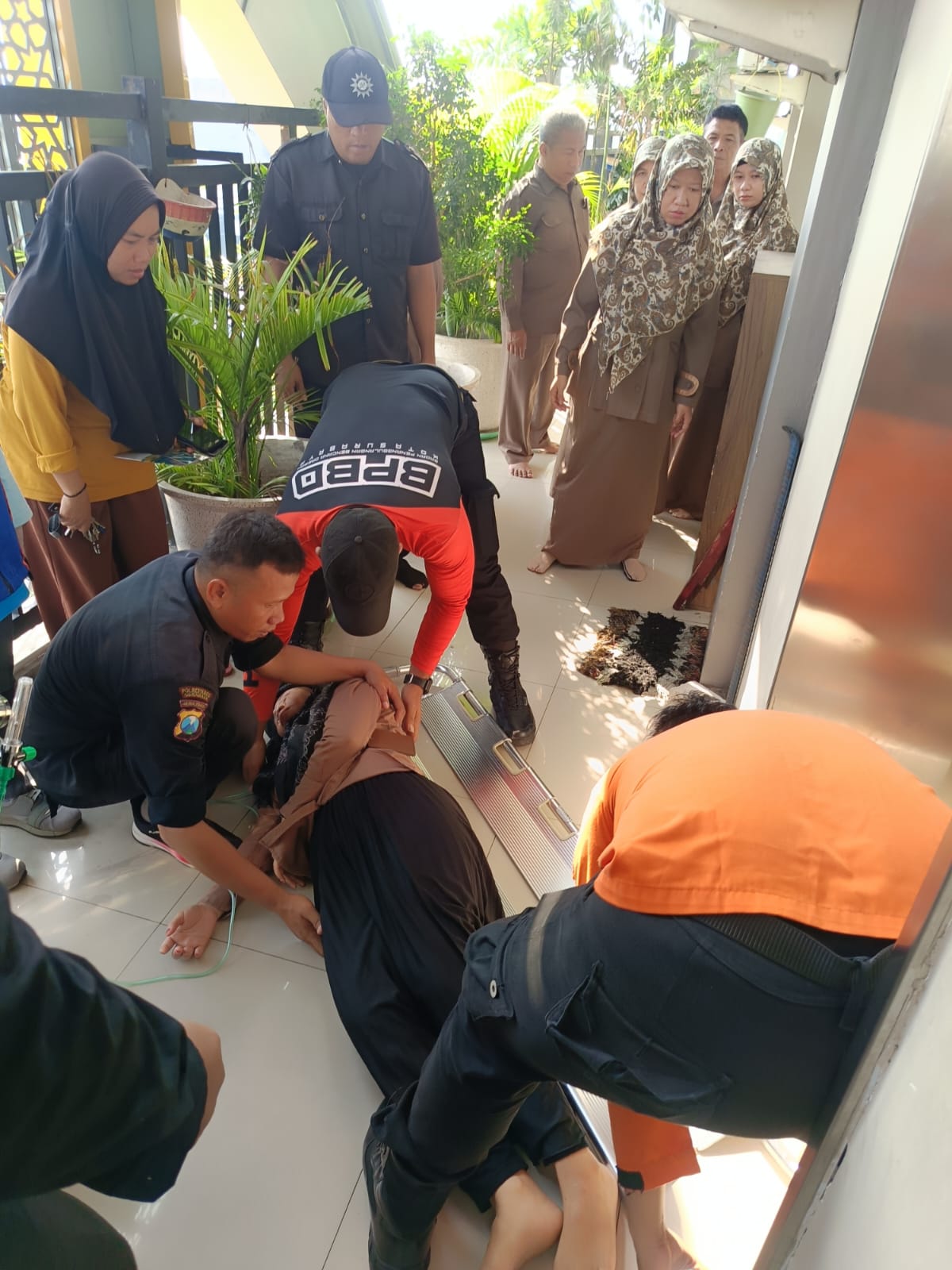 SELAMAT : Petugas BPBD Surabaya saat membantu penanganan awal guru yang terjebak di dalam lift SMP Muhammadiyah, Manukan Kulon, Surabaya. (IST/RADAR SURABAYA)