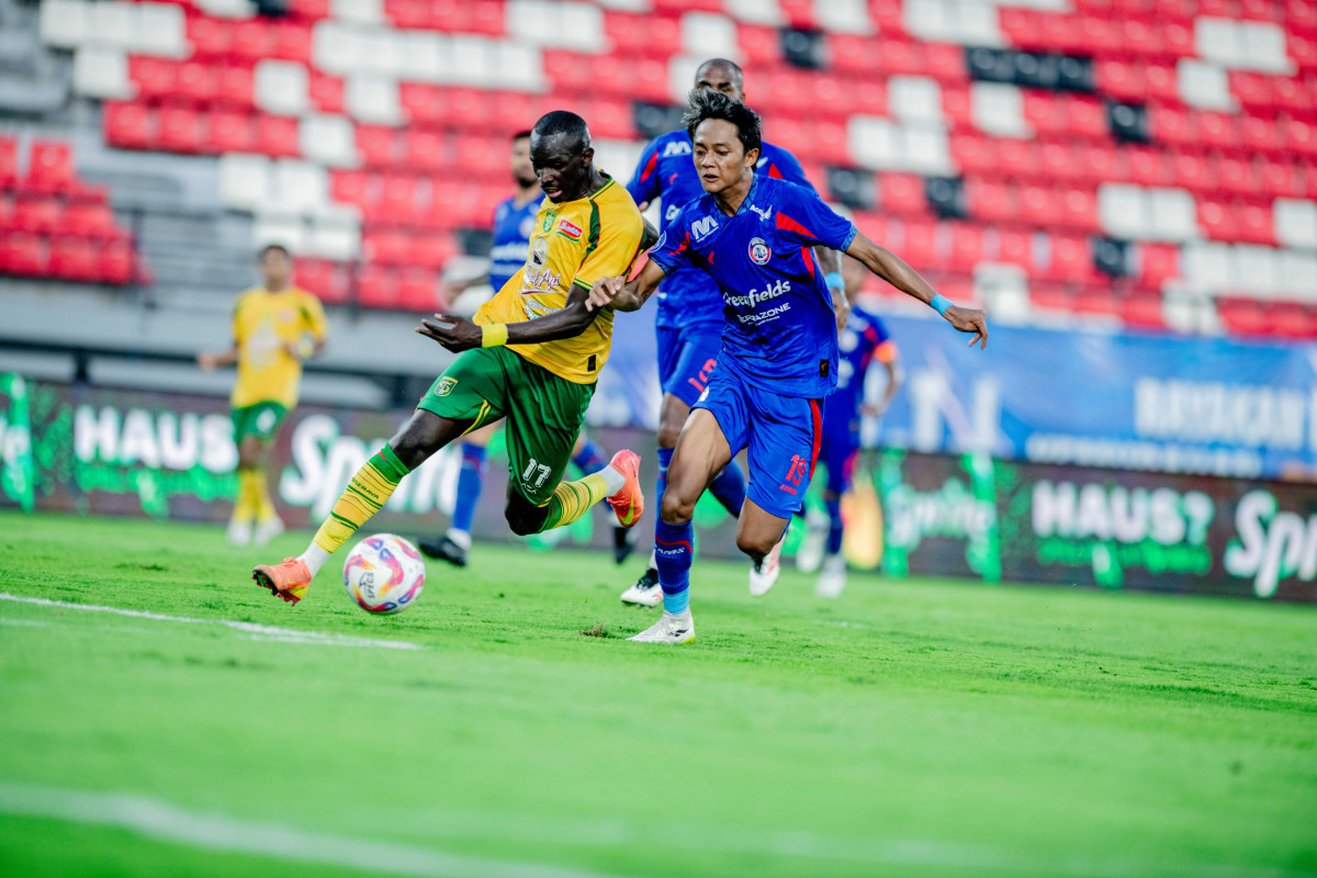 Flavio Silva (kiri) coba lewati adangan pemain Arema FC.