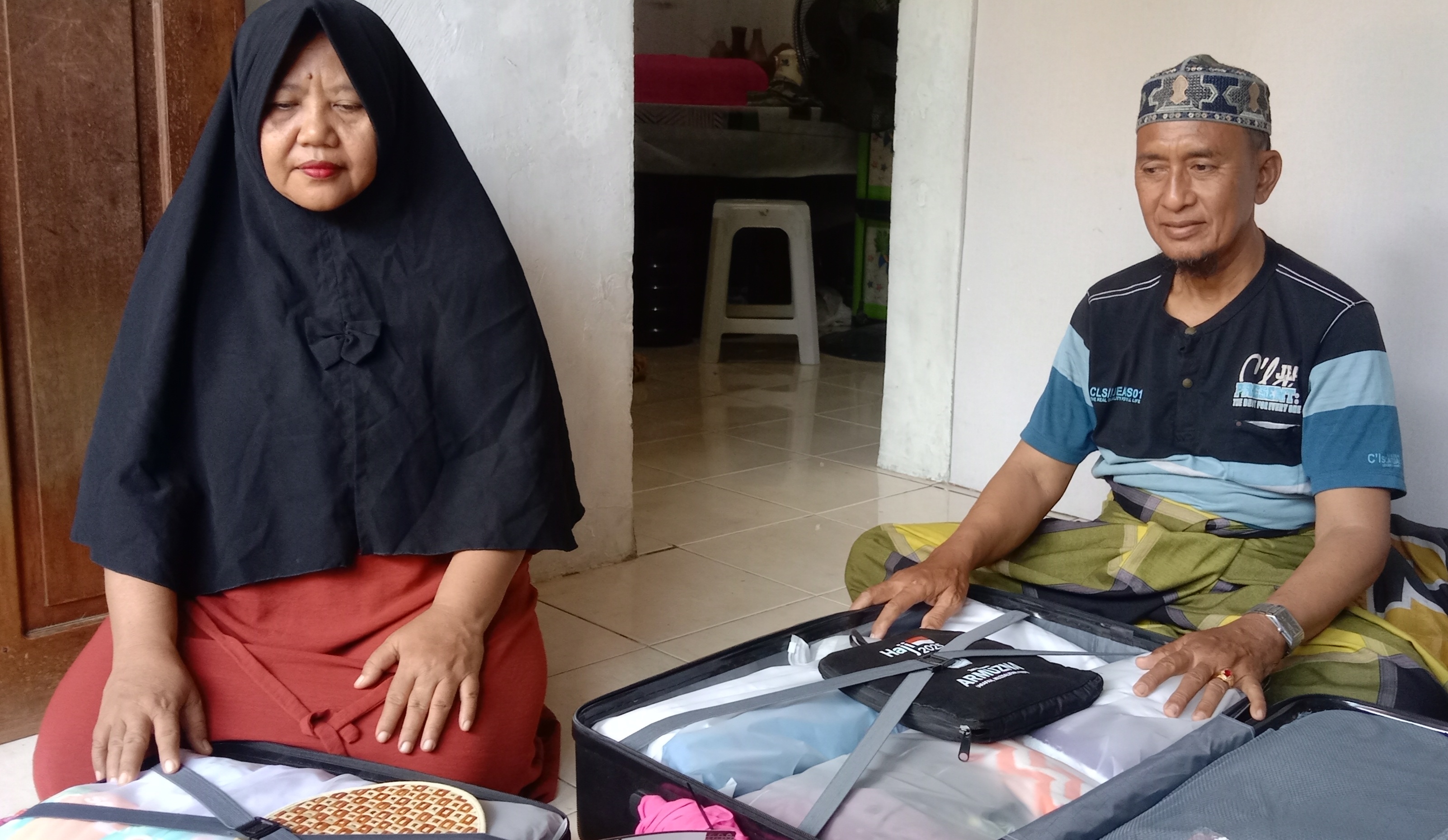 TAMU ALLAH: Rochmad Munandar yang berprofesi sebagai tukang pijat urut sehari-harinya saat memasukan barang bawaan ke koper bersama sang istri Yuli khotimah menjelang keberangkatan ke Tanah Suci.