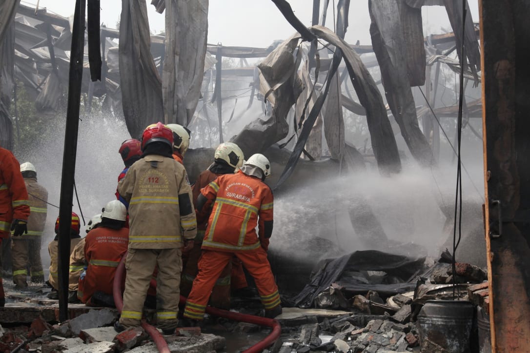 PEMBASAHAN : Petugas DPKP Surabaya berusaha memadamkan api yang membakar bangunan gudang penyimpanan bahan kimia di pergudangan Tambak Langon Indah, Surabaya.(SURYANTO/RADAR SURABAYA)