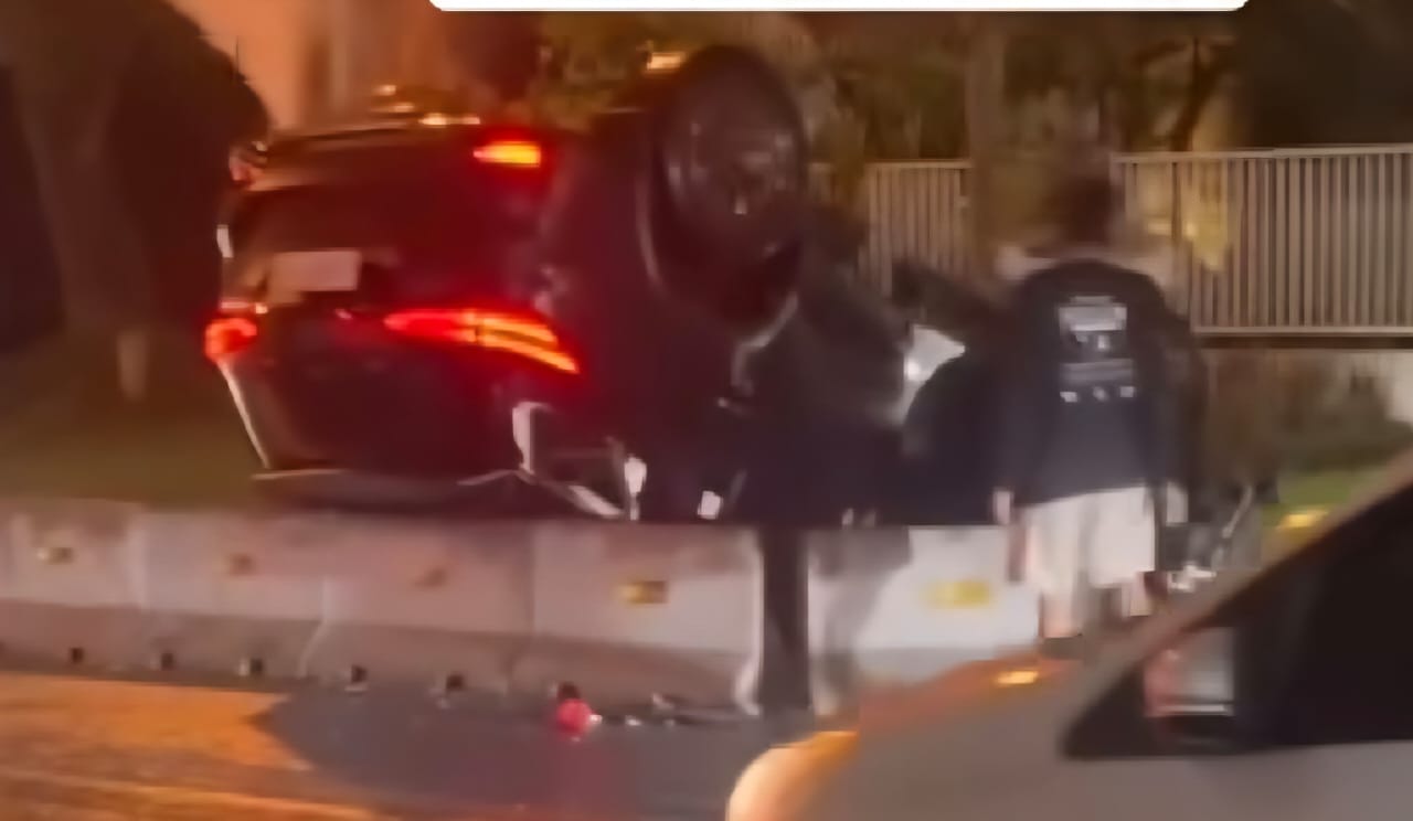 BERASAP : Mobil Toyota Fortuner ini terbalik usai menabrak pembatas jalan di salah satu perumahan elit di kawasan Surabaya Barat. (MAHRUS/RADAR SURABAYA)