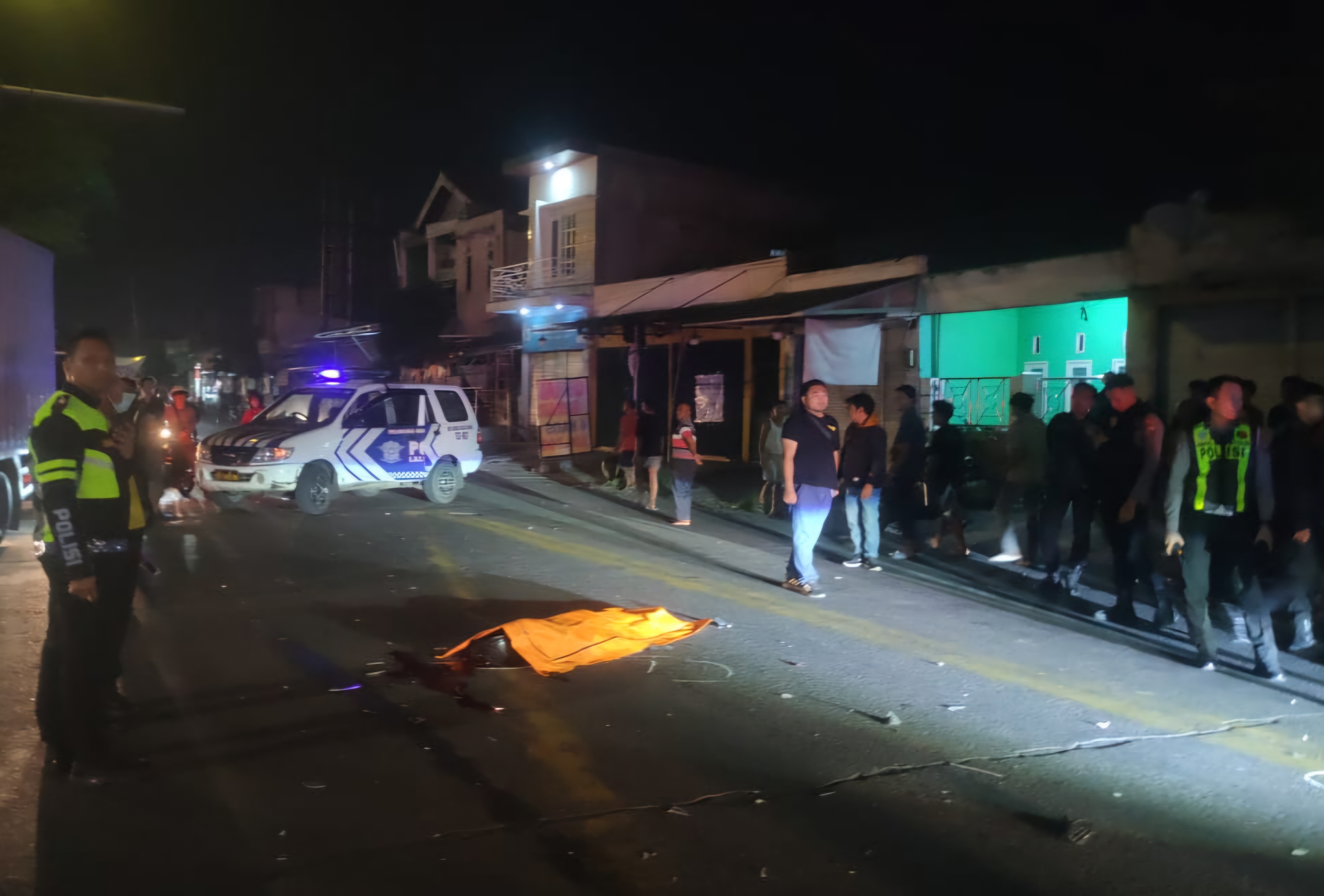 LOKASI : Polisi saat mengamankan jenazah korban kecelakaan mobil tabrak motor di Bundaran Karangpoh, Jalan Raya Tandes Lor, Surabaya. (IST/RADAR SURABAYA)