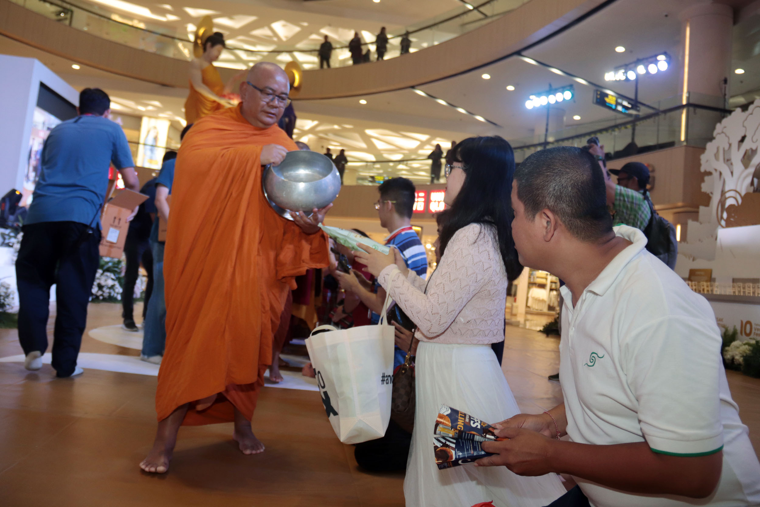 Biksu dari enam negara menerima makanan dari umat Budha dalam prosesi Pindapata yang digelar dalam acara Vesak Festival 2025.