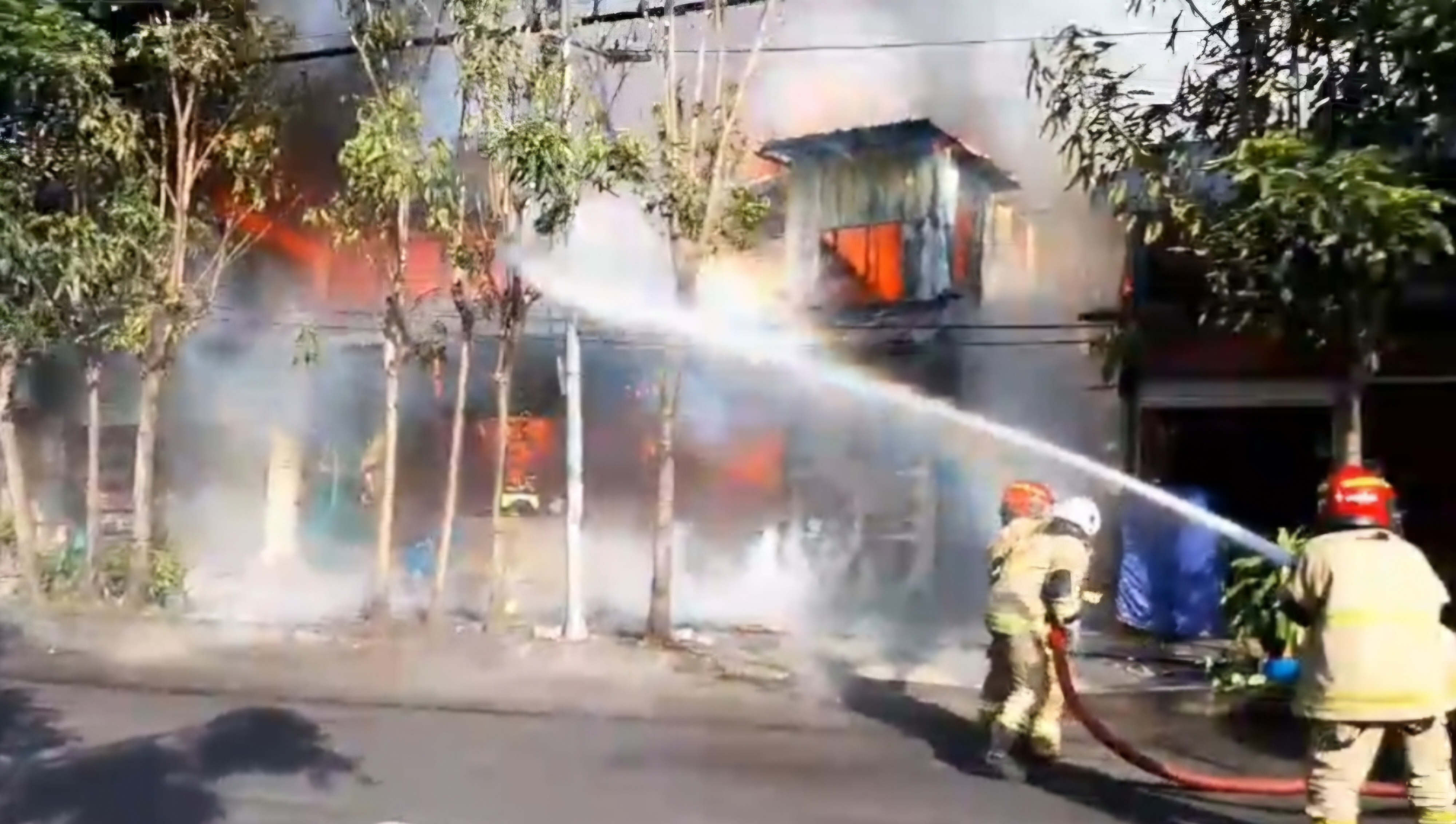 BERJIBAKU : Petugas DPKP Surabaya saat memadamkan kebakaran lima kios dan satu rumah di Jalan Semarang, Surabaya. (IST/RADAR SURABAYA)